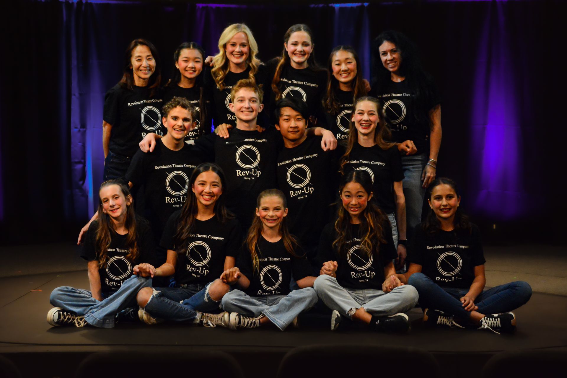 A group of young girls are posing for a picture on a stage.