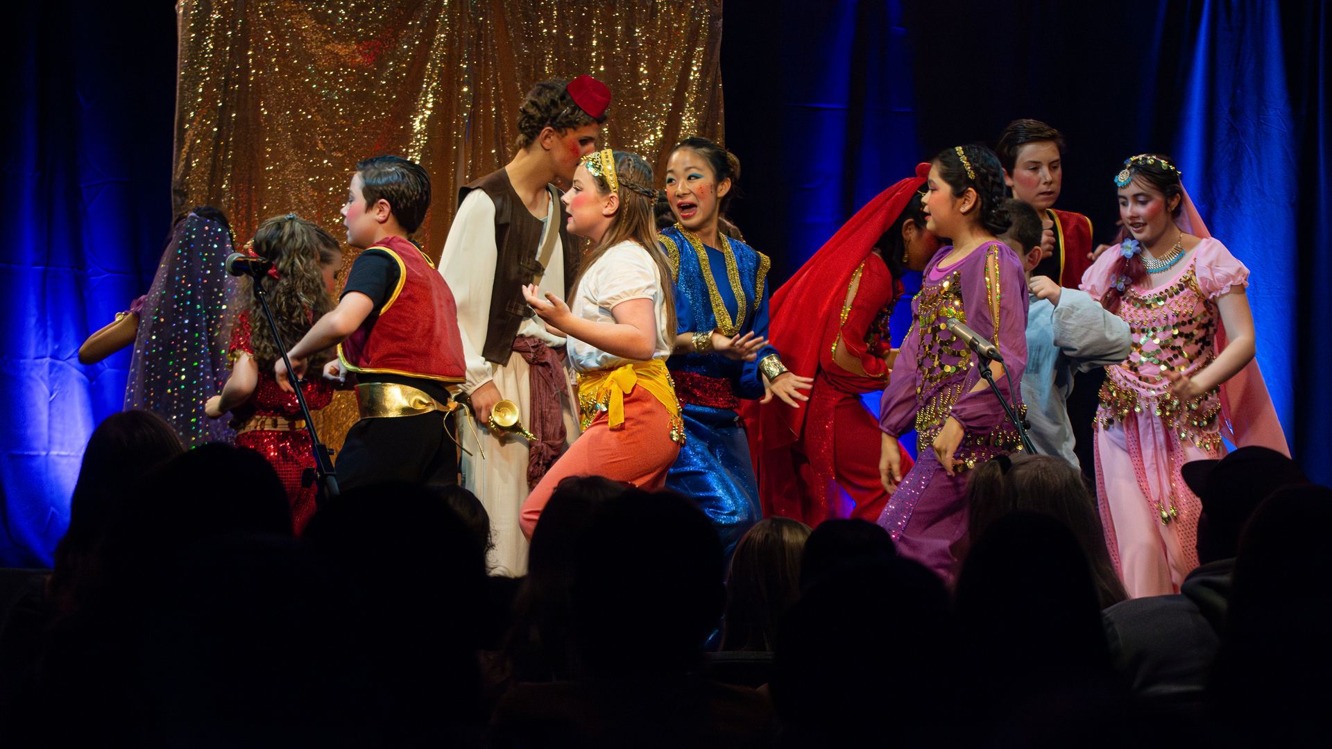 A group of people are dancing on a stage in front of a crowd.