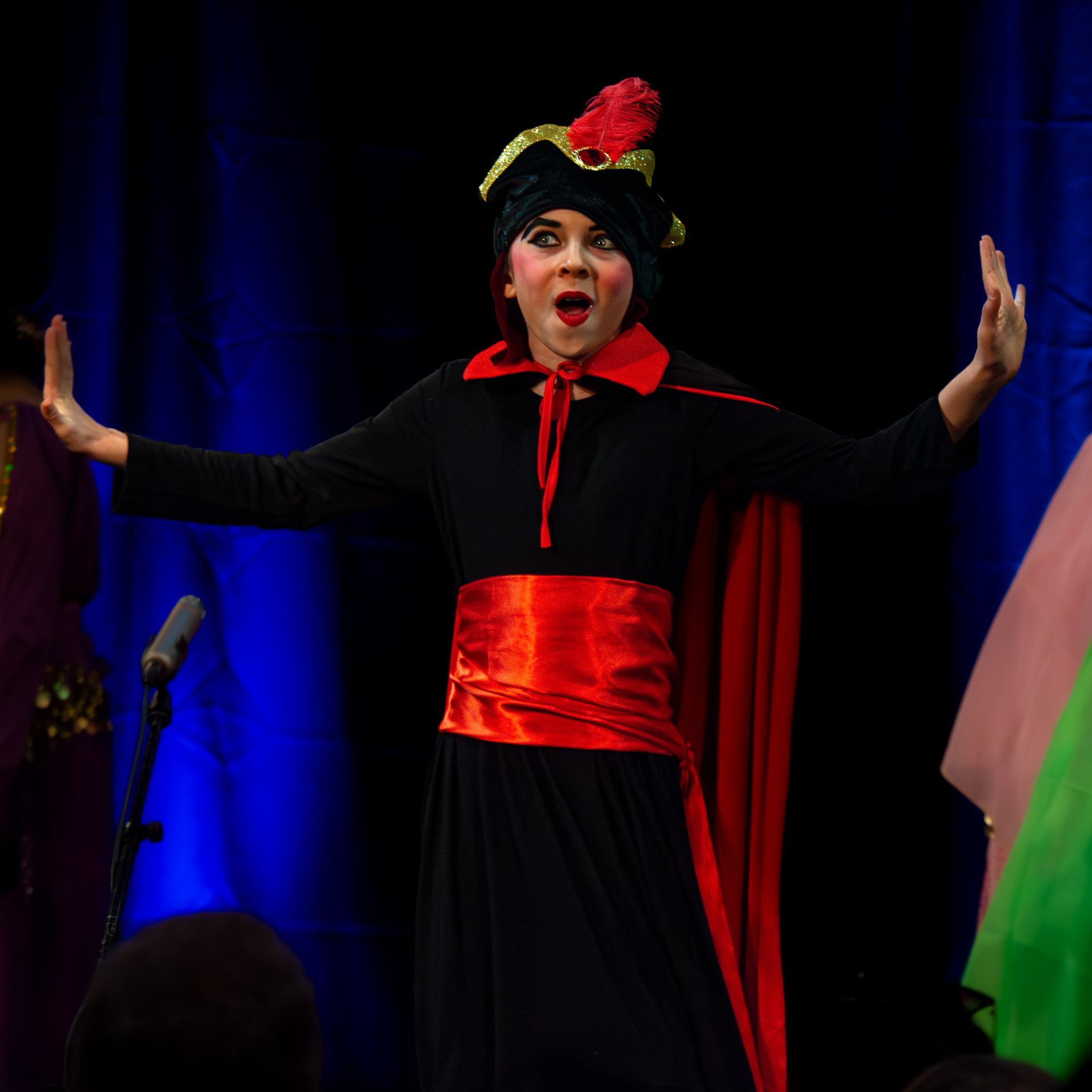 A woman in a black dress with a red sash around her waist