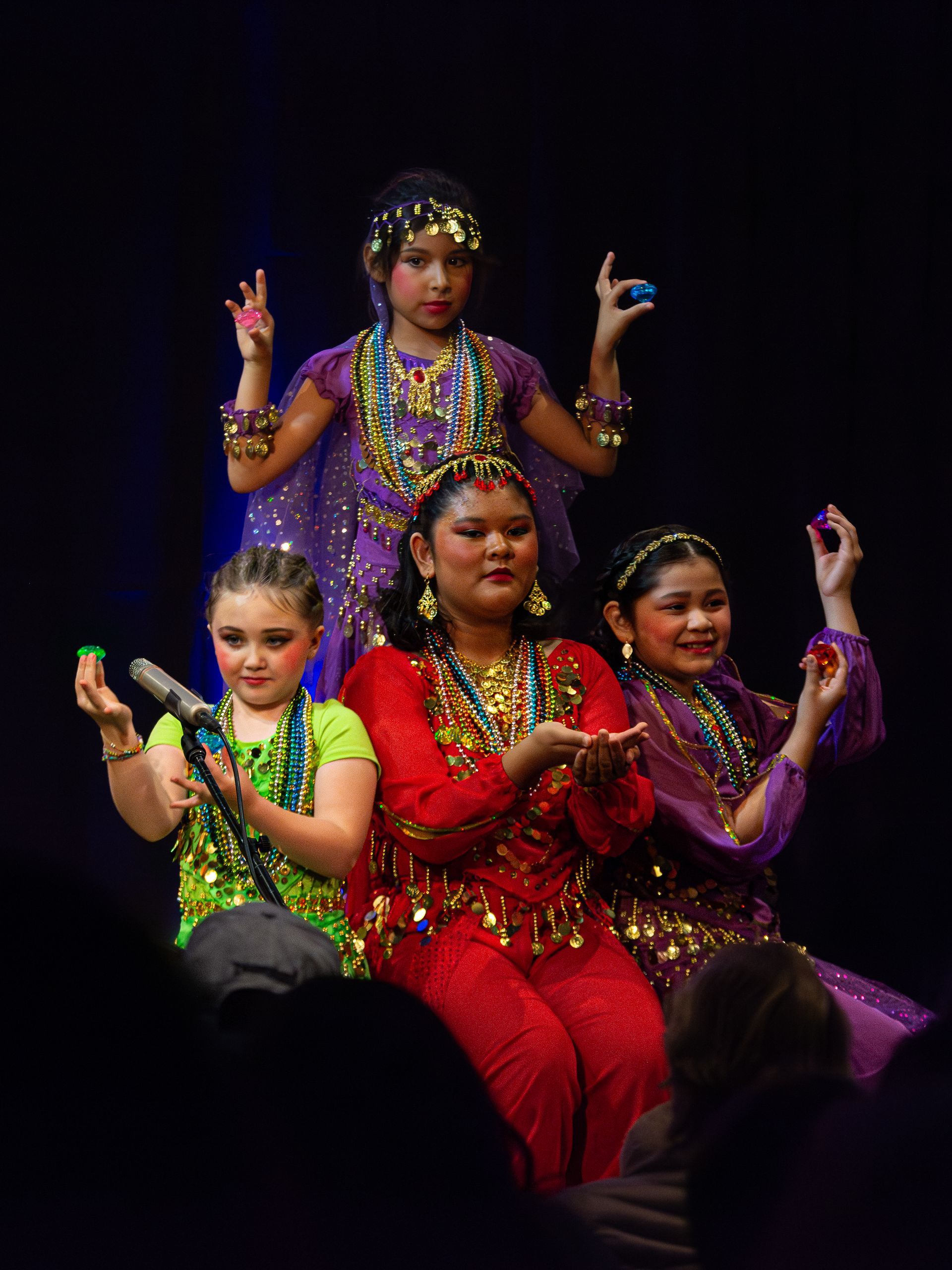 A group of young girls are performing a dance on stage