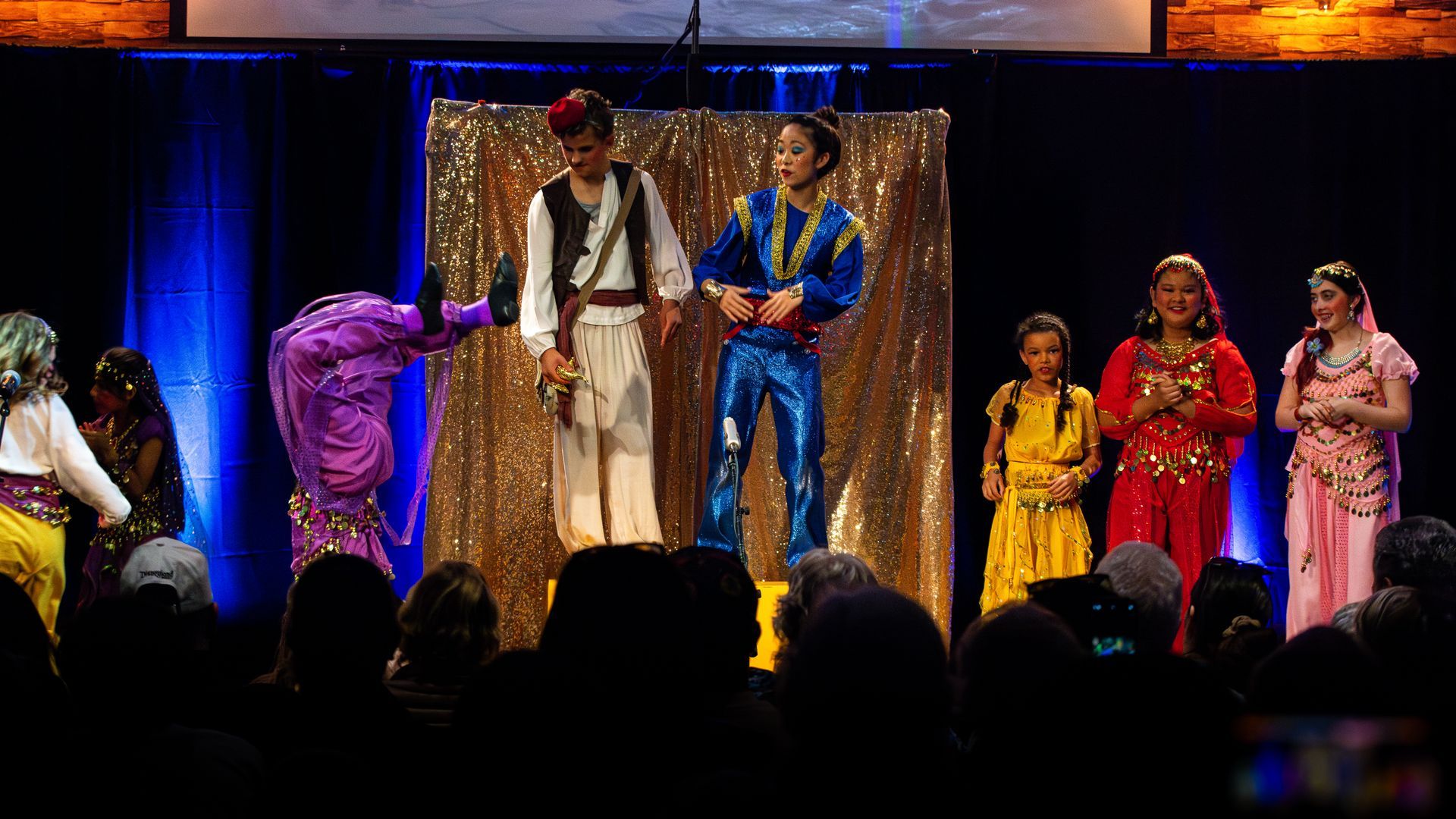 A group of people are standing on a stage in front of a crowd.