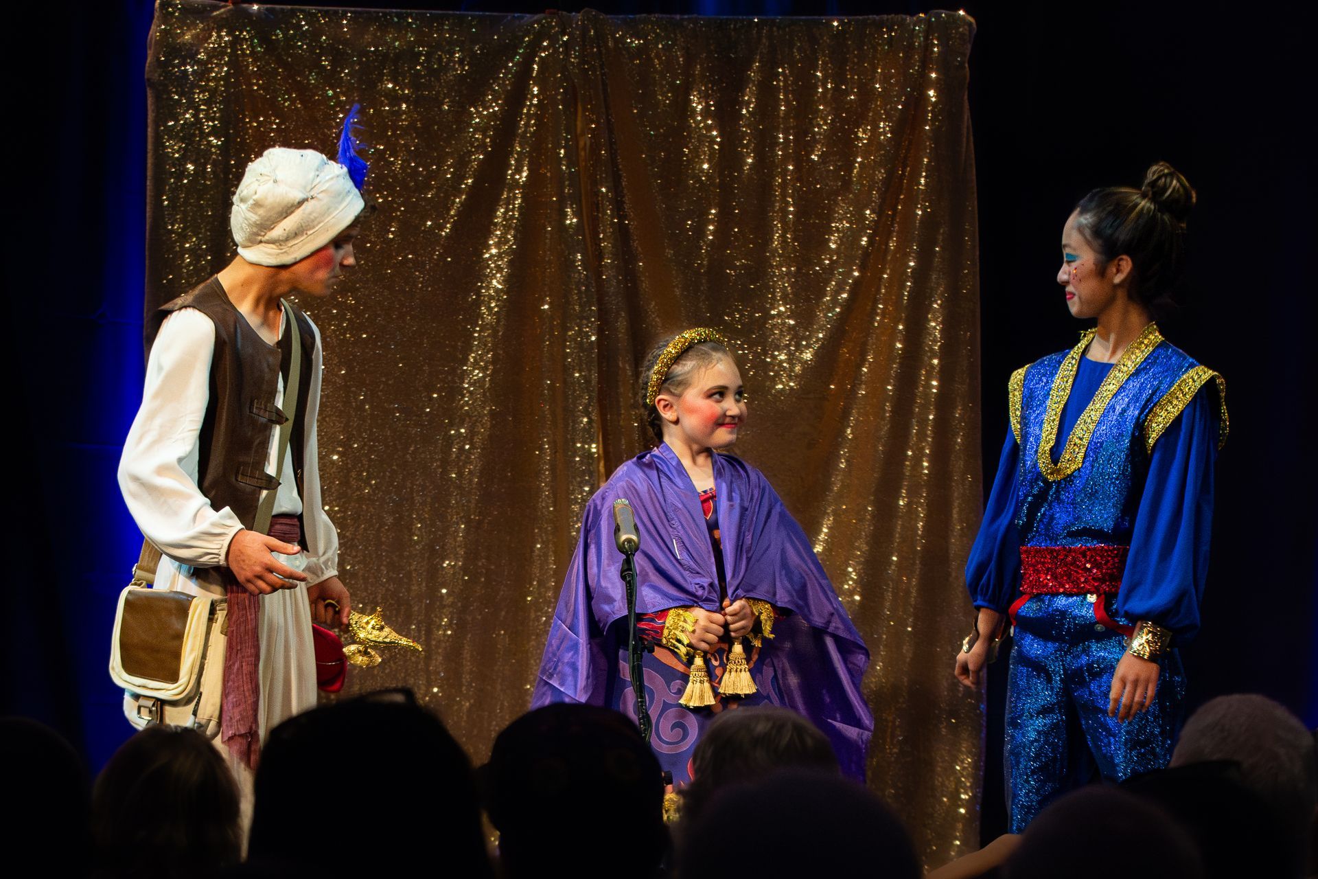 A group of people are standing on a stage talking to each other.