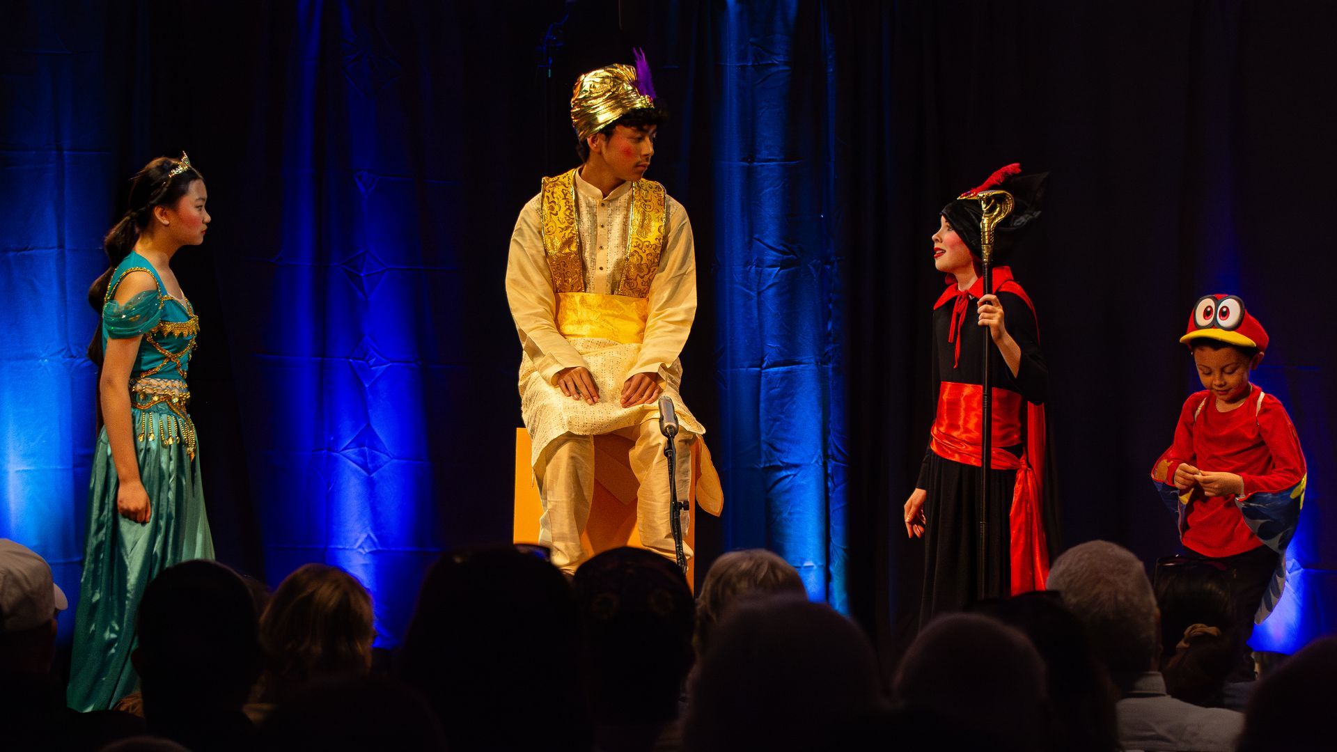 A group of people are standing on a stage in front of a crowd.