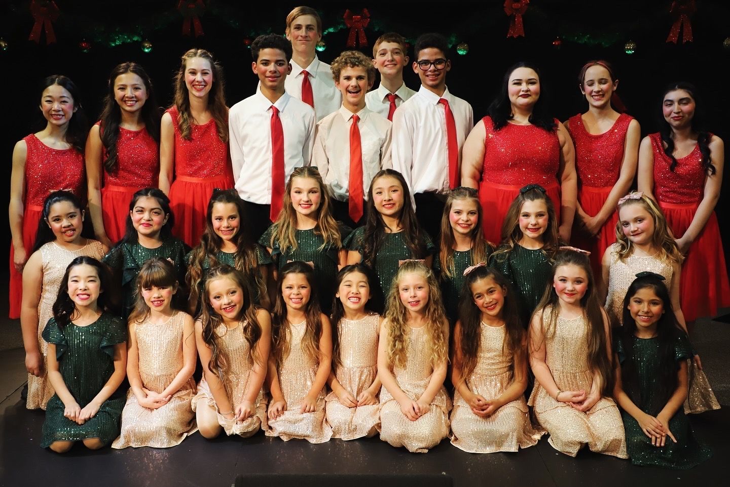 A group of young people are posing for a picture on a stage.