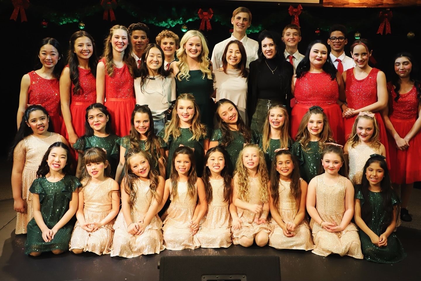 A group of young girls are posing for a picture on a stage.