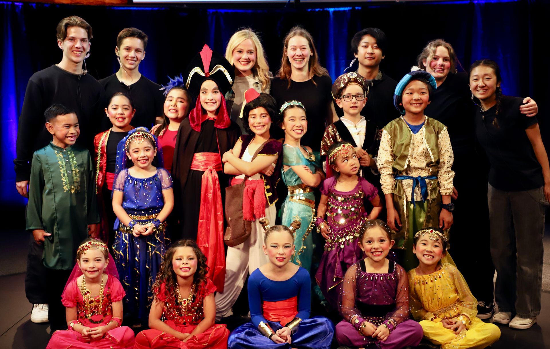 A group of children are posing for a picture on a stage.