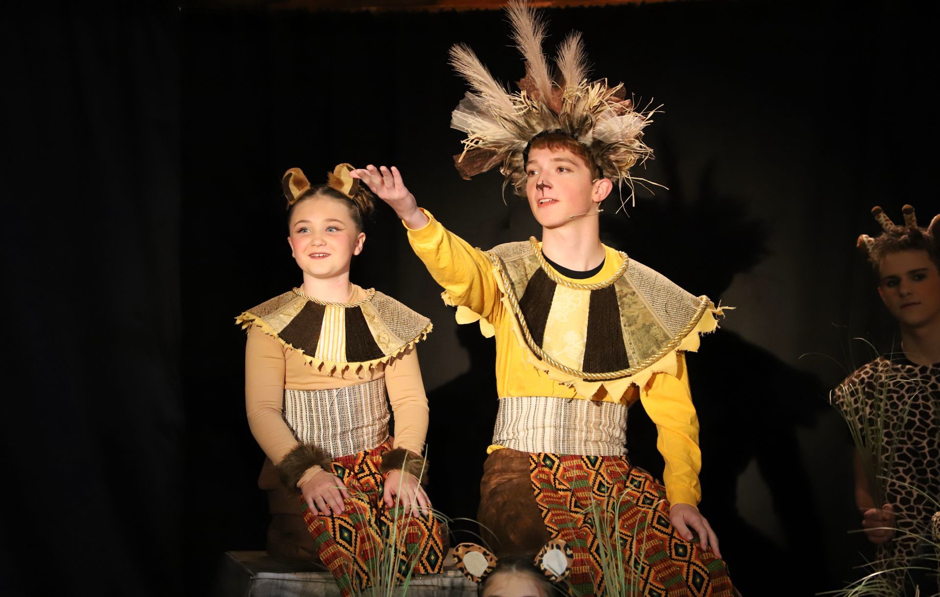 A boy and a girl are standing next to each other on a stage.