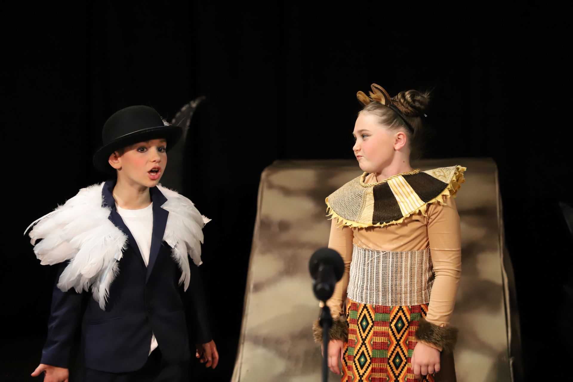 A boy and a girl are standing next to each other on a stage.