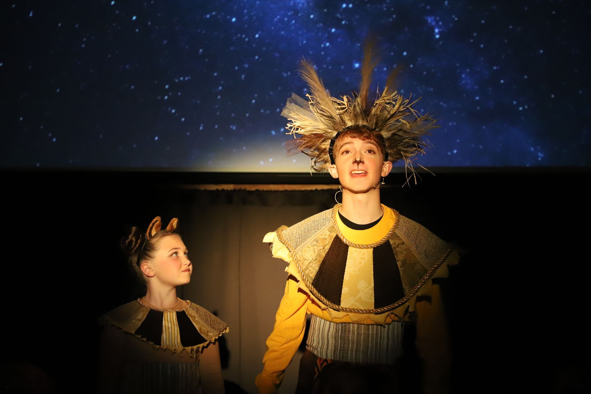 A man and a woman are standing next to each other on a stage.