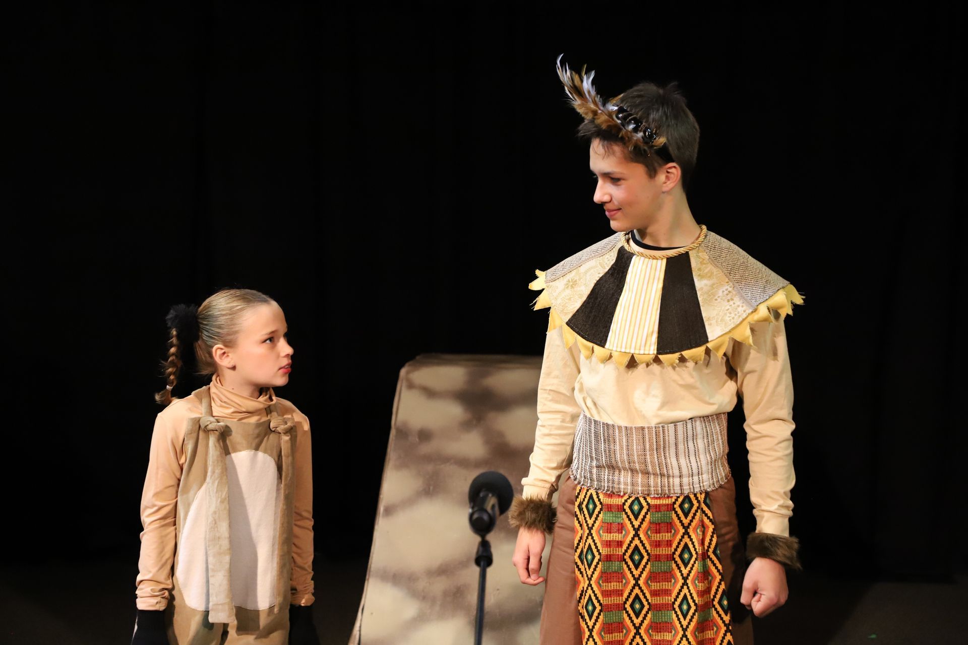 A boy and a girl are standing next to each other on a stage.