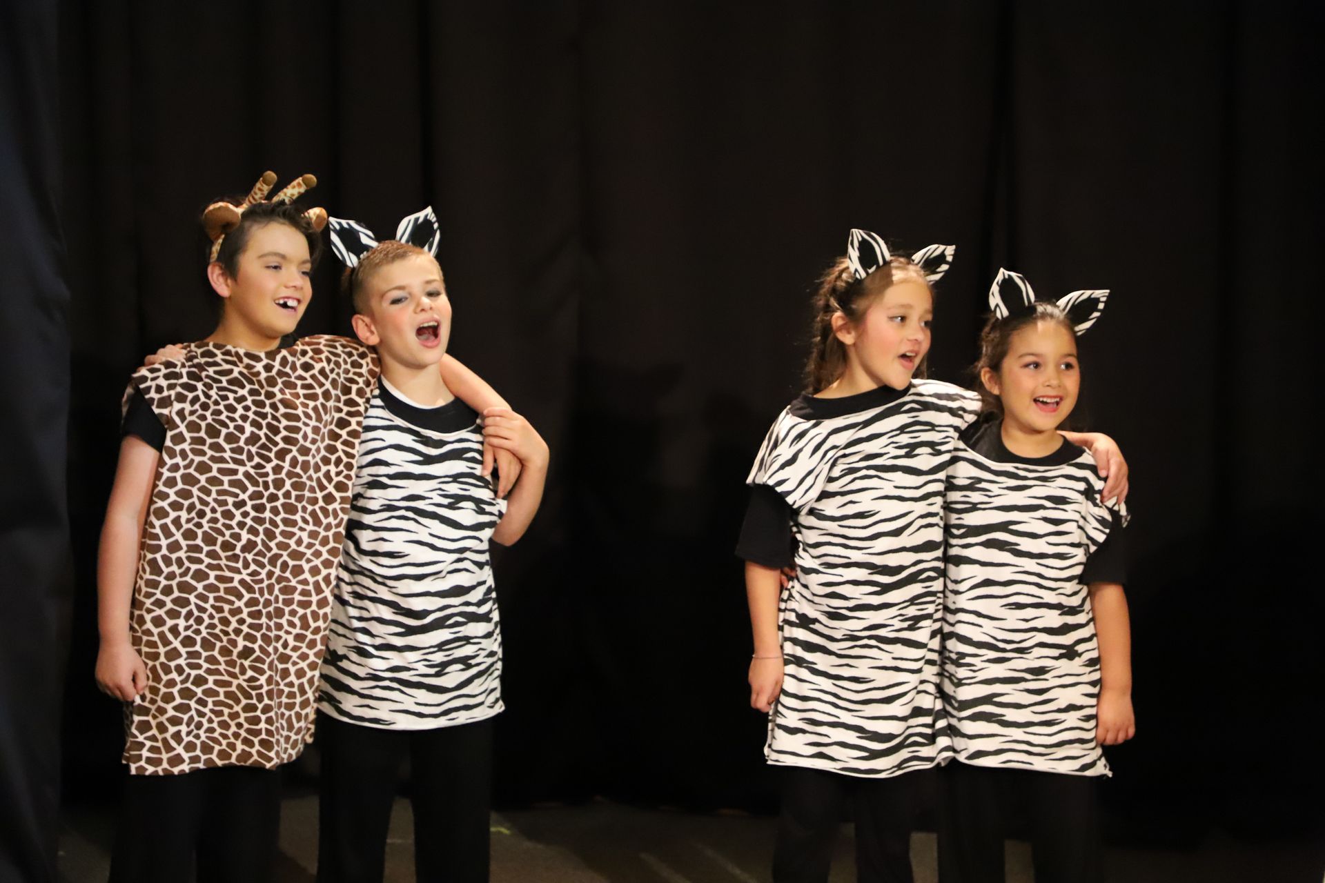 A boy and two girls are standing next to each other on a stage.
