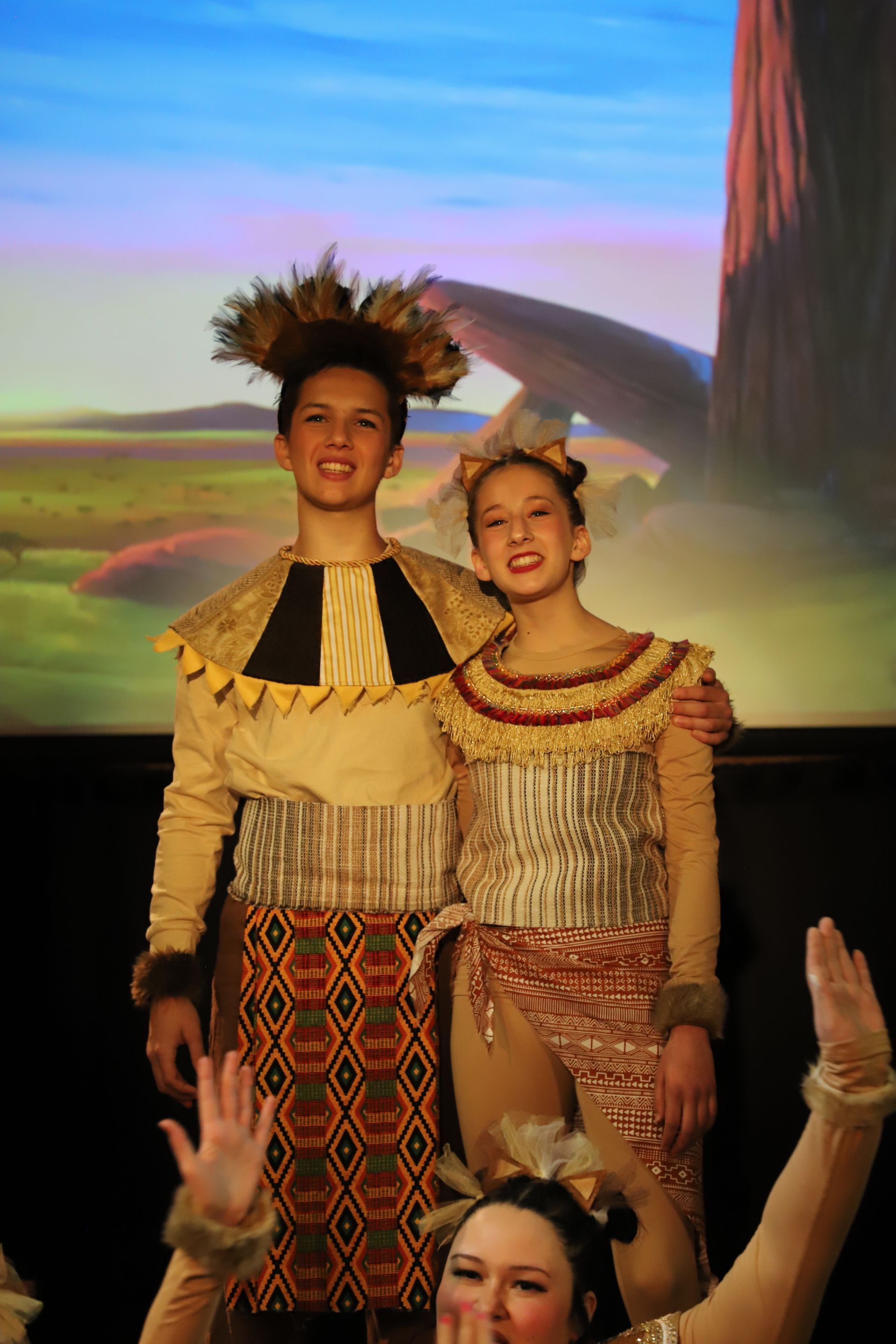 A group of people in costumes are standing next to each other on a stage.