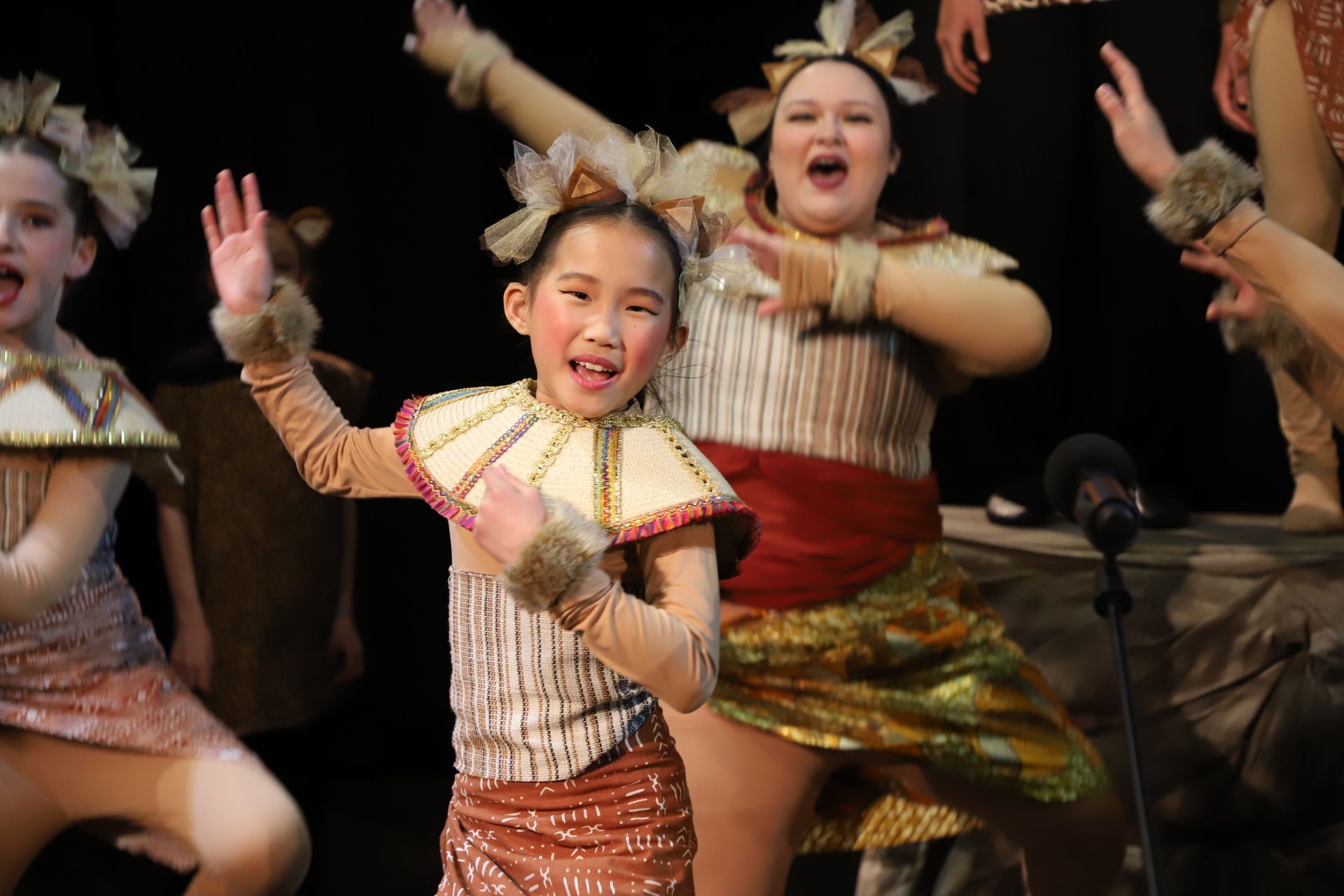 A group of young girls are dancing on a stage.