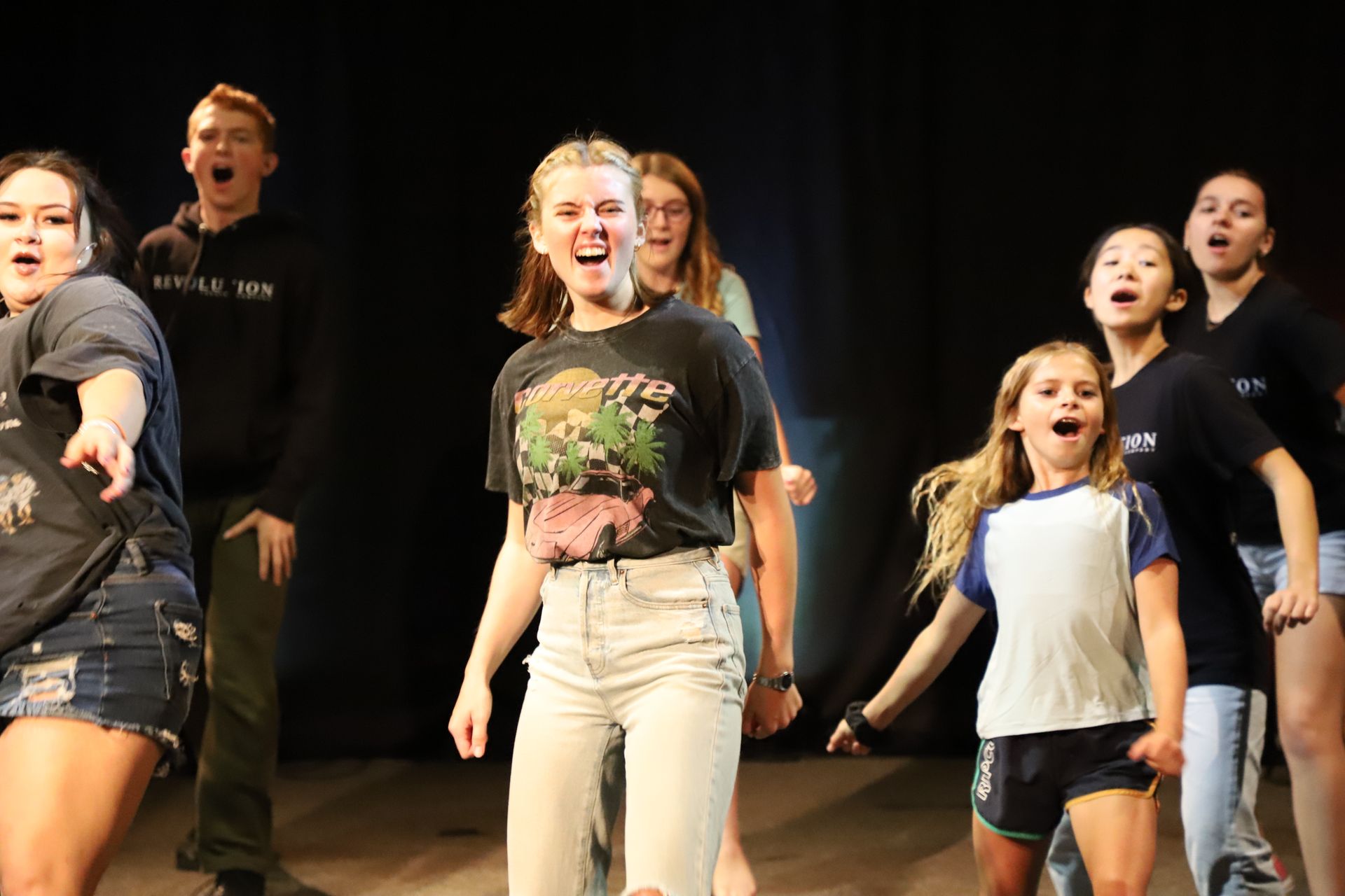 A group of young people are dancing on a stage.