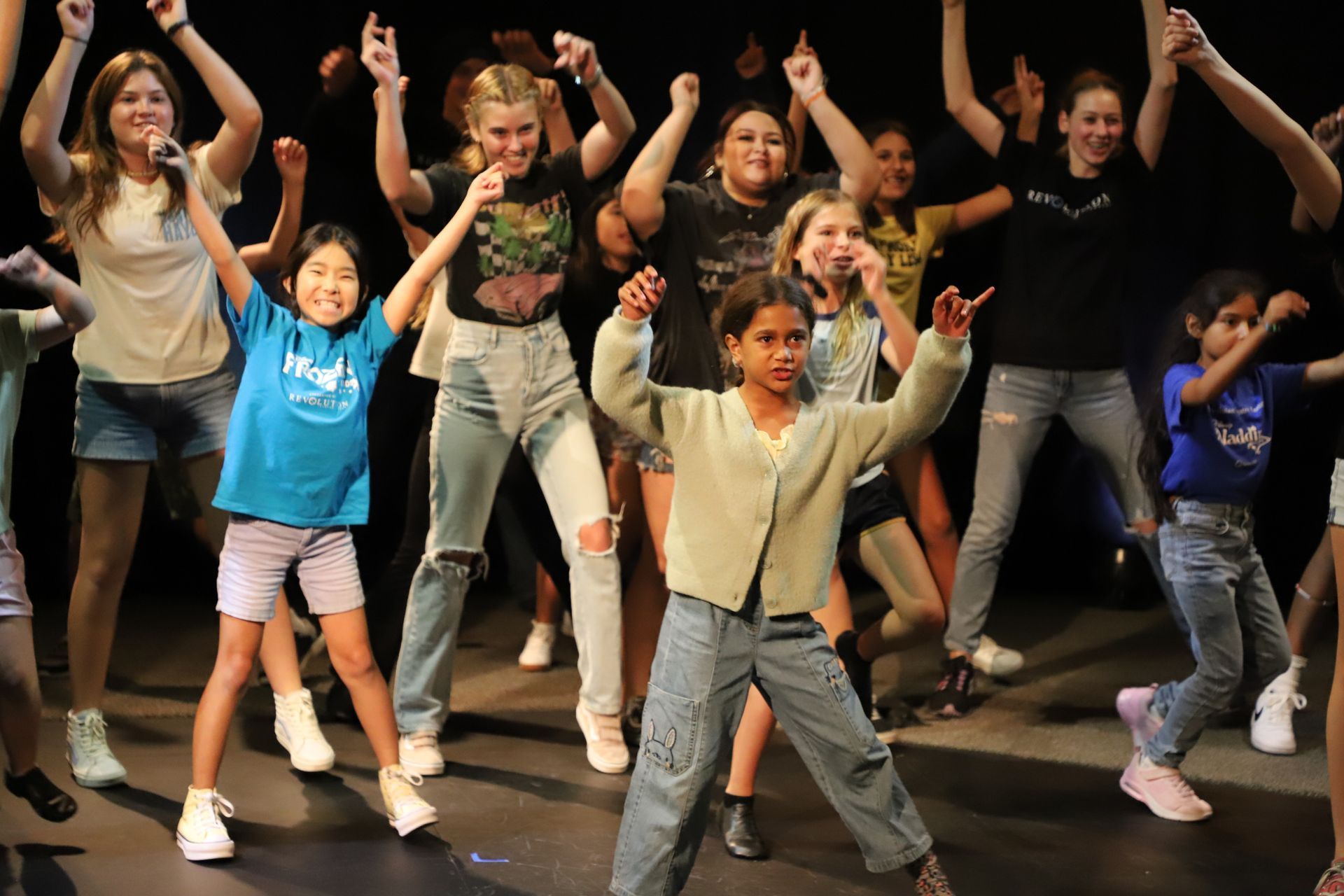 A group of young girls are dancing on a stage.
