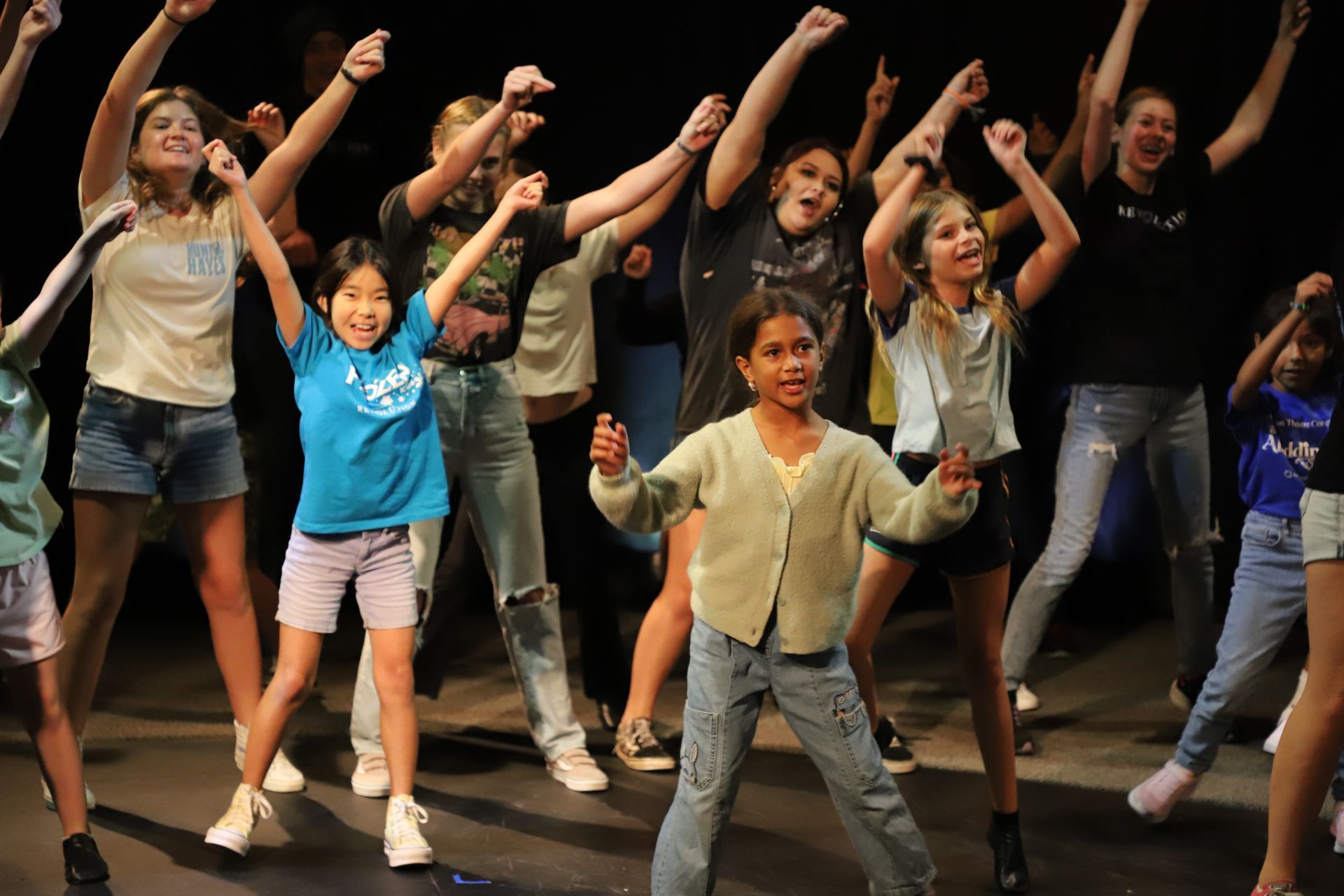 A group of young girls are dancing on a stage.