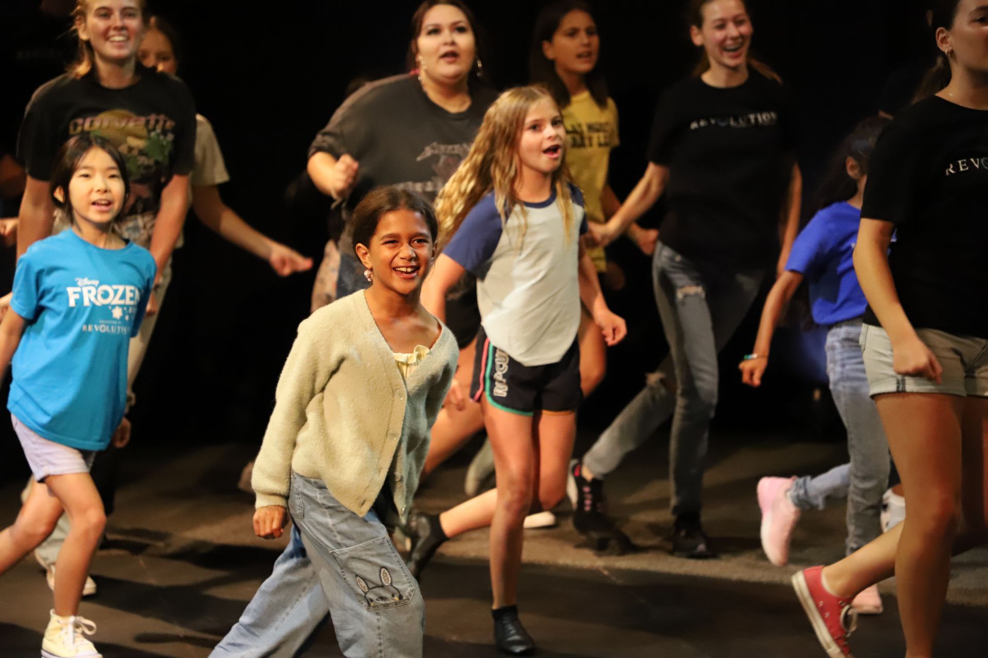 A group of young girls are dancing on a stage.