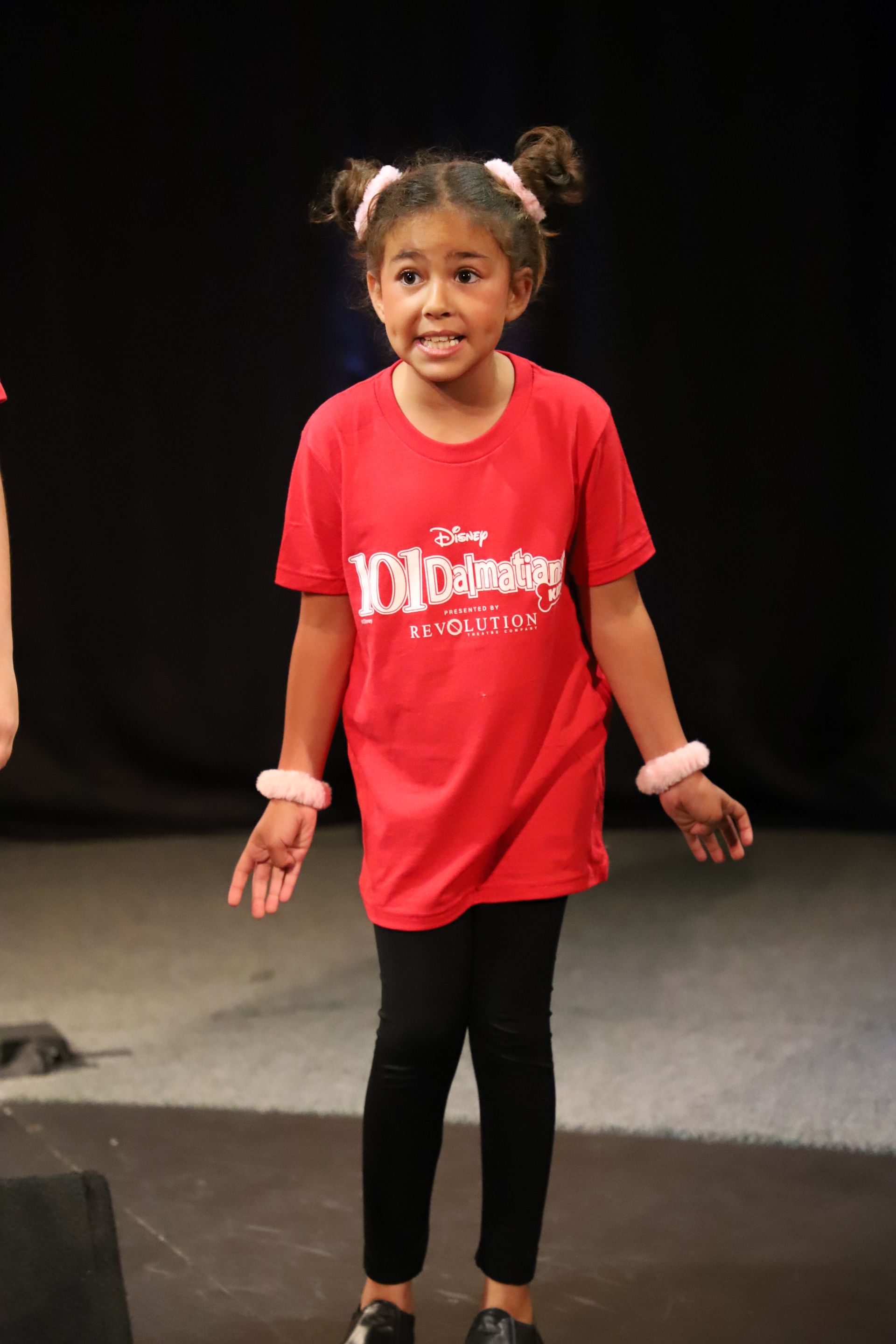 A little girl is wearing a red shirt that says 101 dalmatians