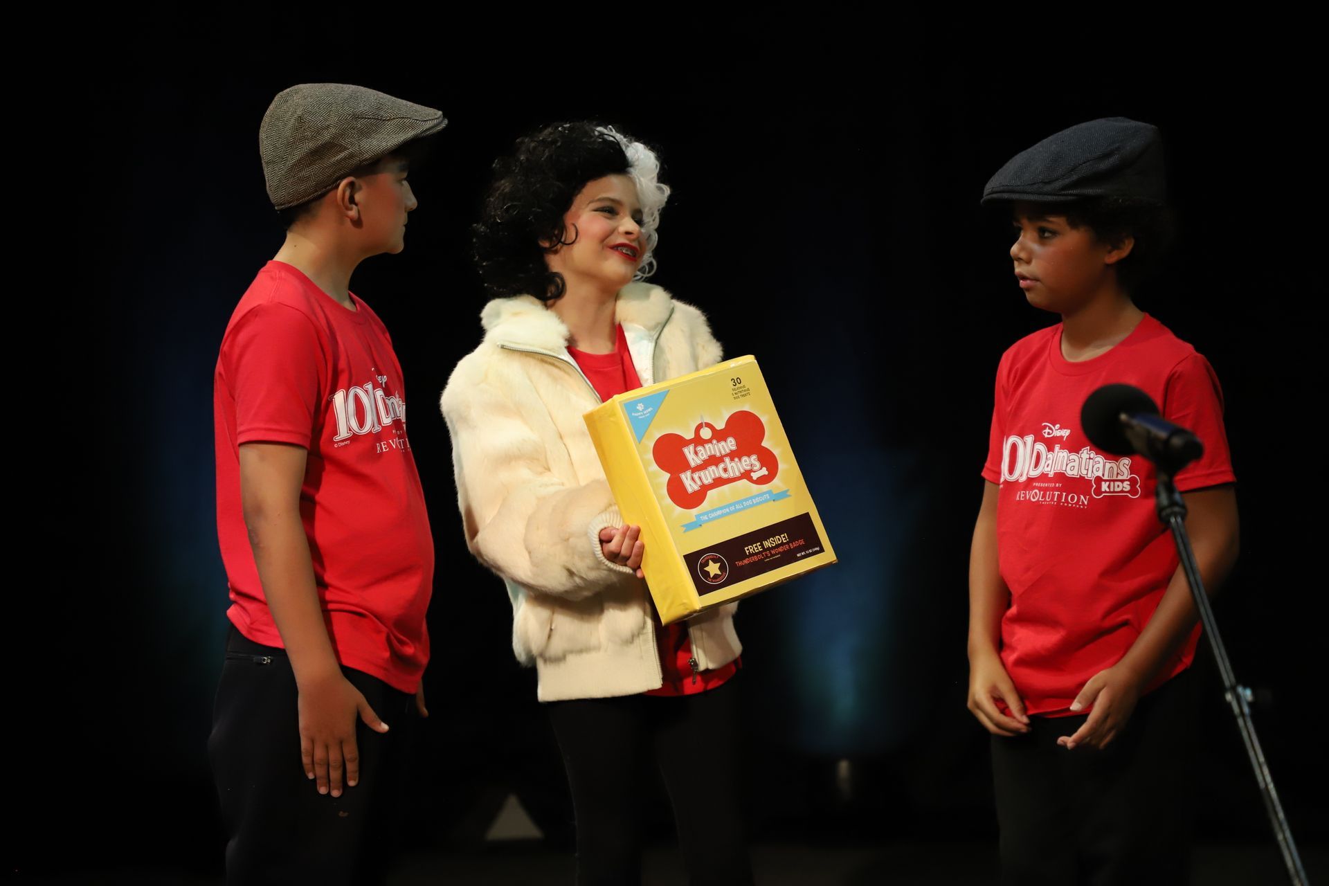 A group of children are standing next to each other on a stage.