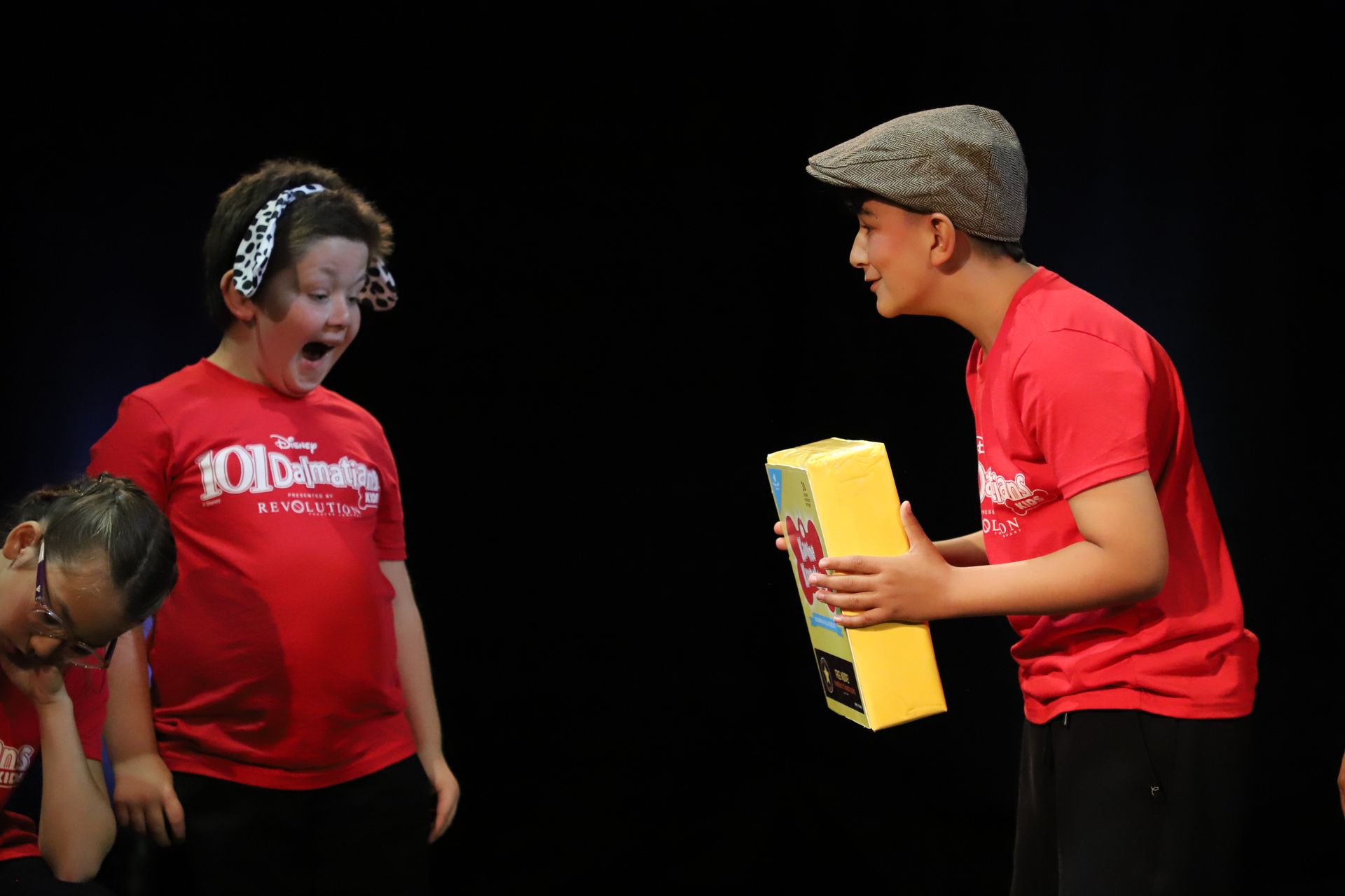 A boy in a red shirt is standing next to a girl in a red shirt.