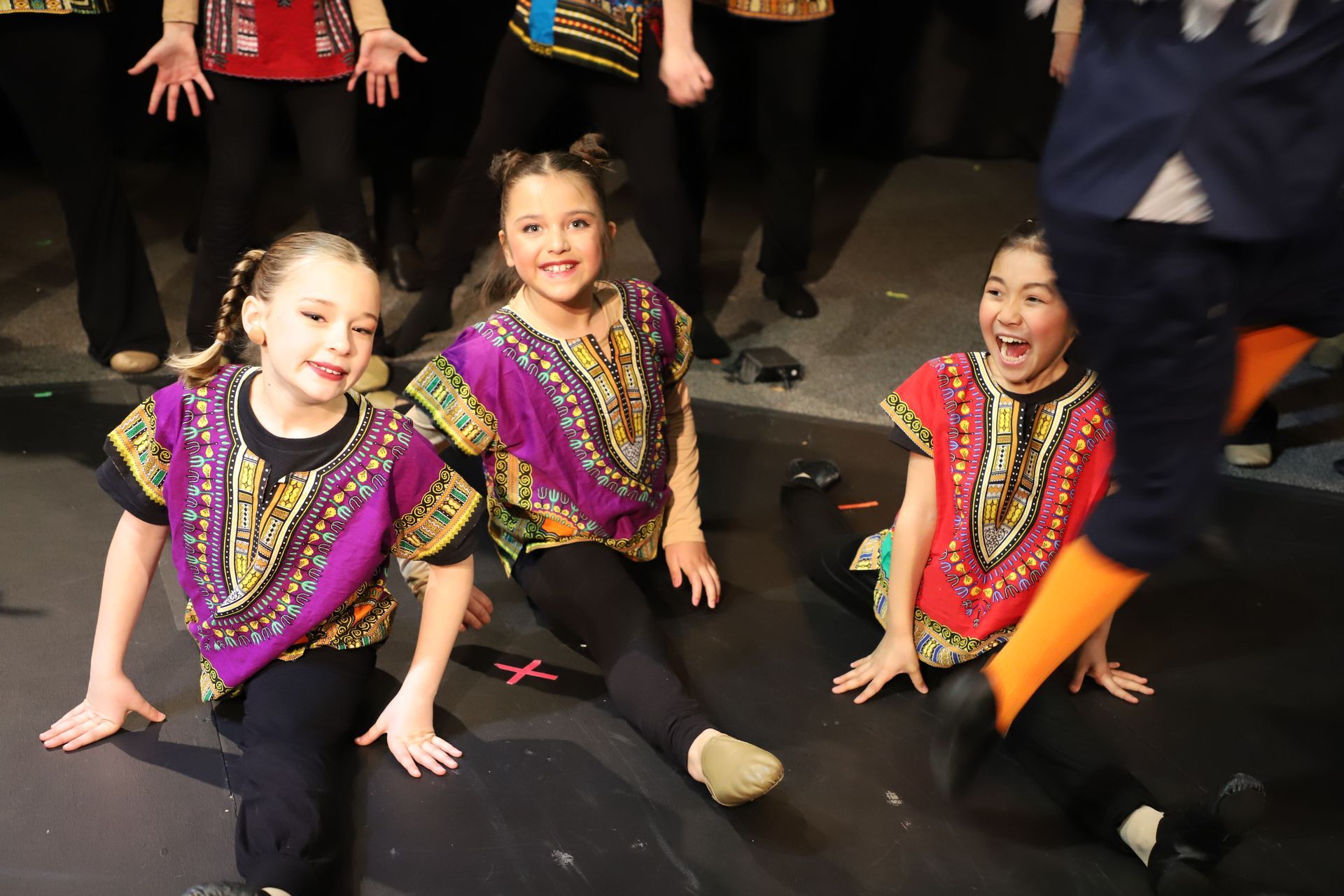 A group of young girls are sitting on the floor