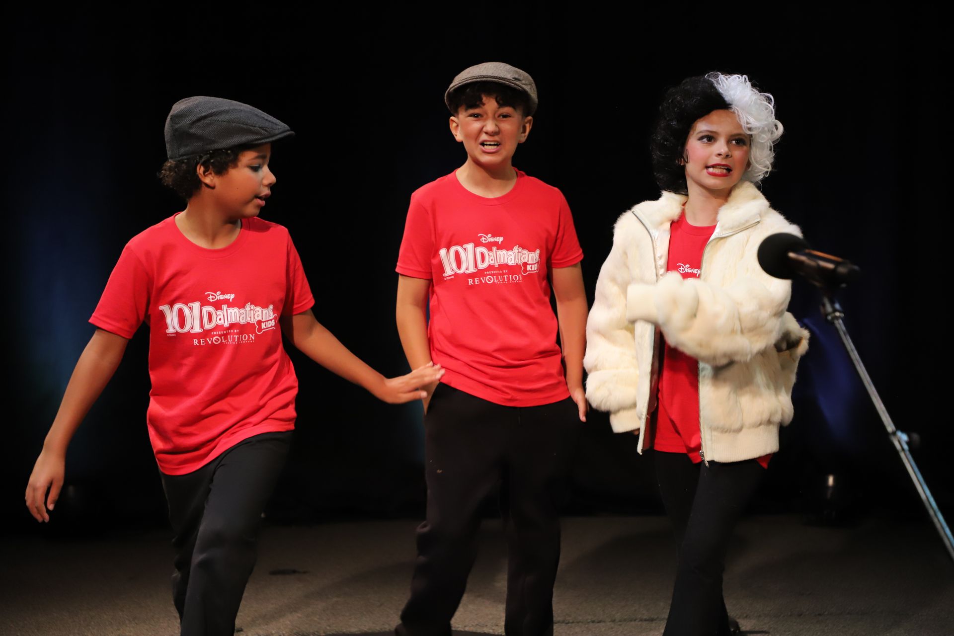 A group of children are standing next to each other on a stage.