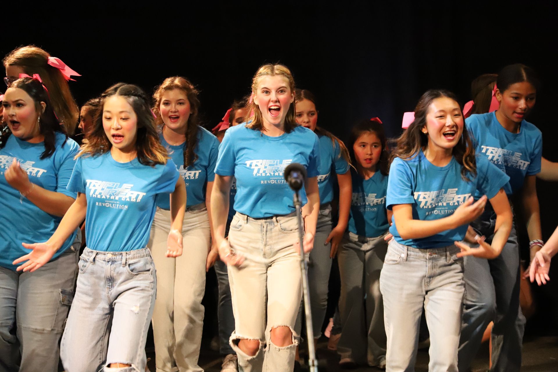 A group of young girls are dancing on a stage.