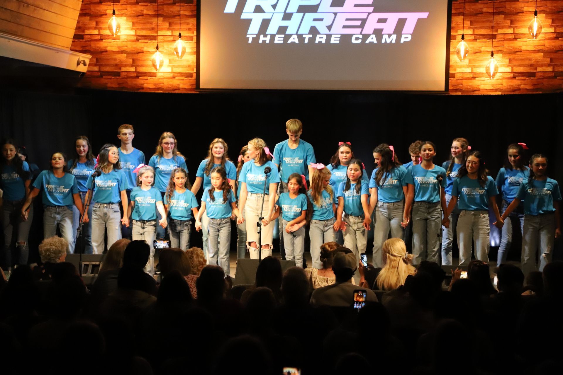 A group of children and teens on stage singing
