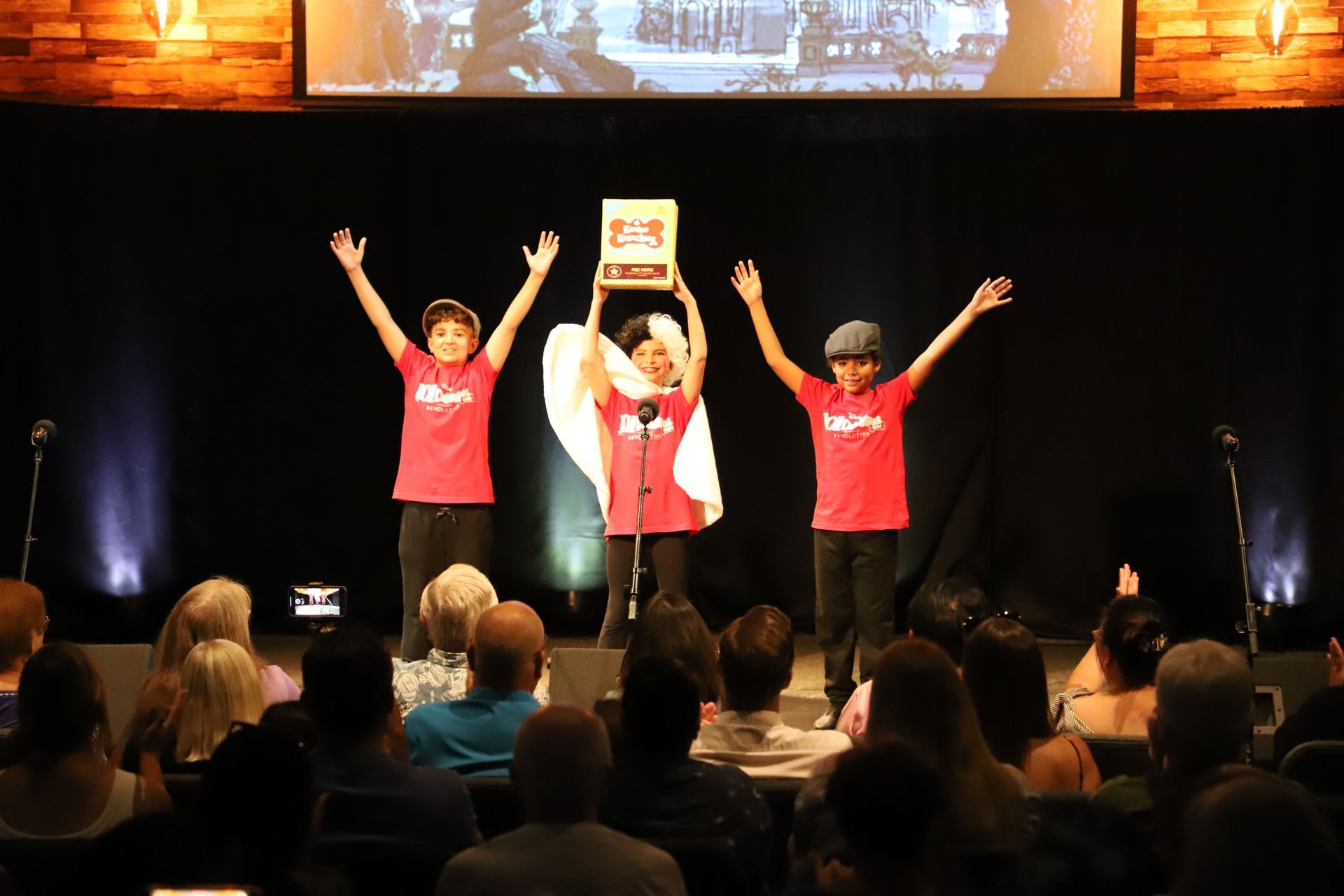 A group of people are standing on a stage with their arms in the air