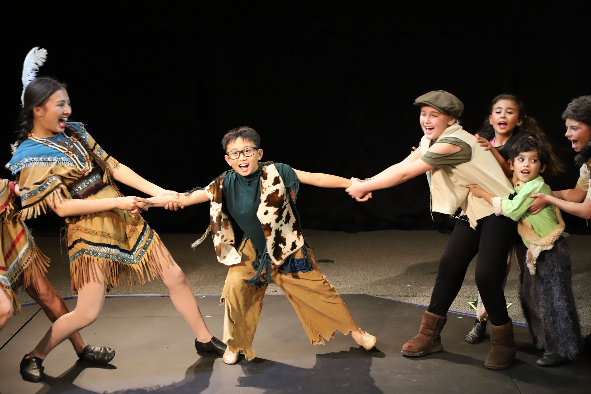 A group of children are playing tug-of-war over another child.