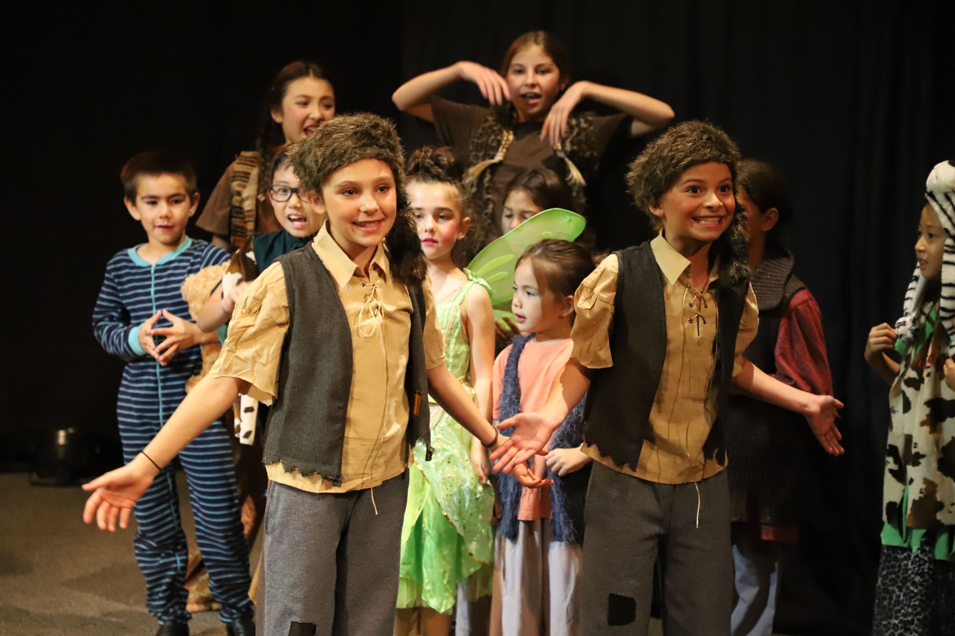 A group of children are posing for a picture on a stage.