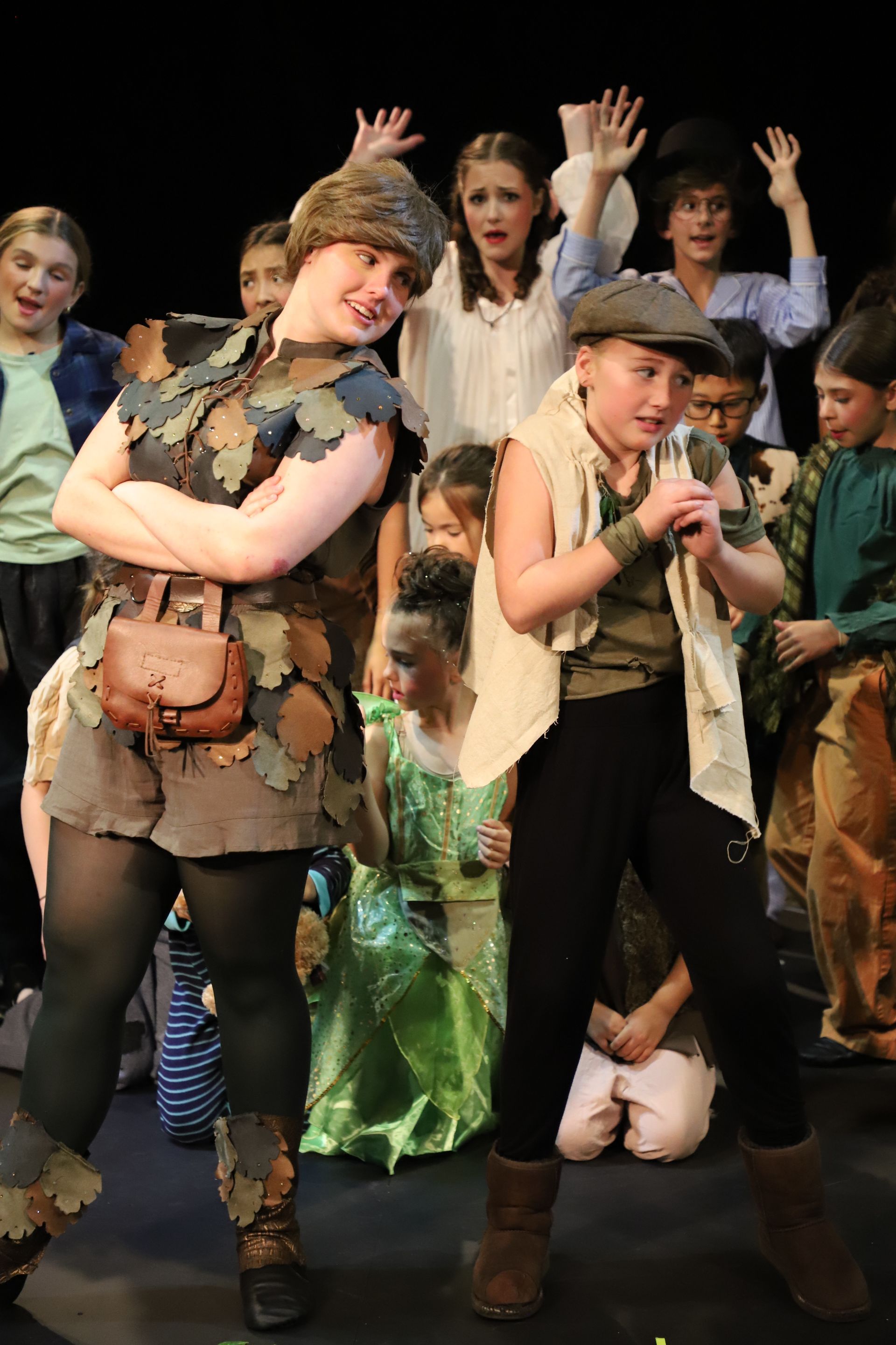 A group of children dressed in costumes are standing on a stage.