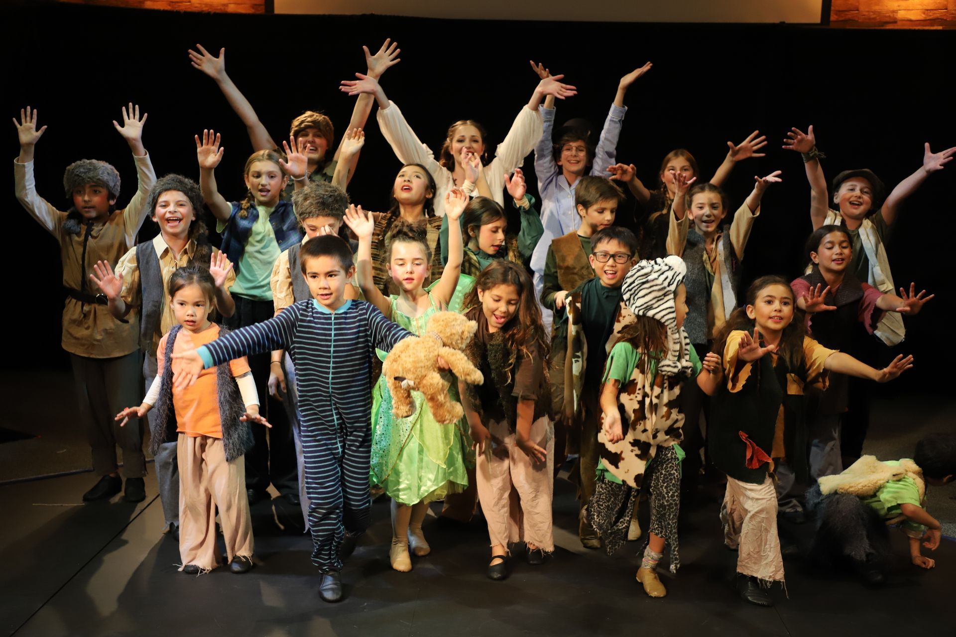 A group of children are posing for a picture on a stage.
