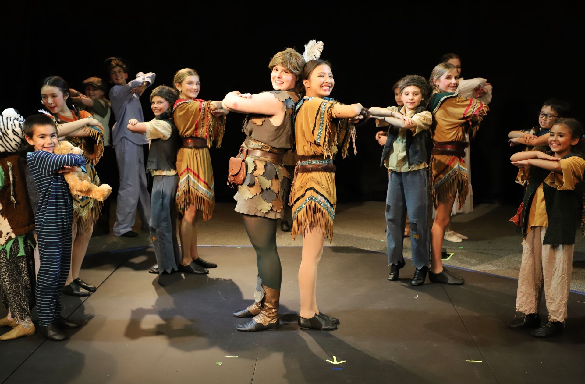 A group of children are dancing on a stage.