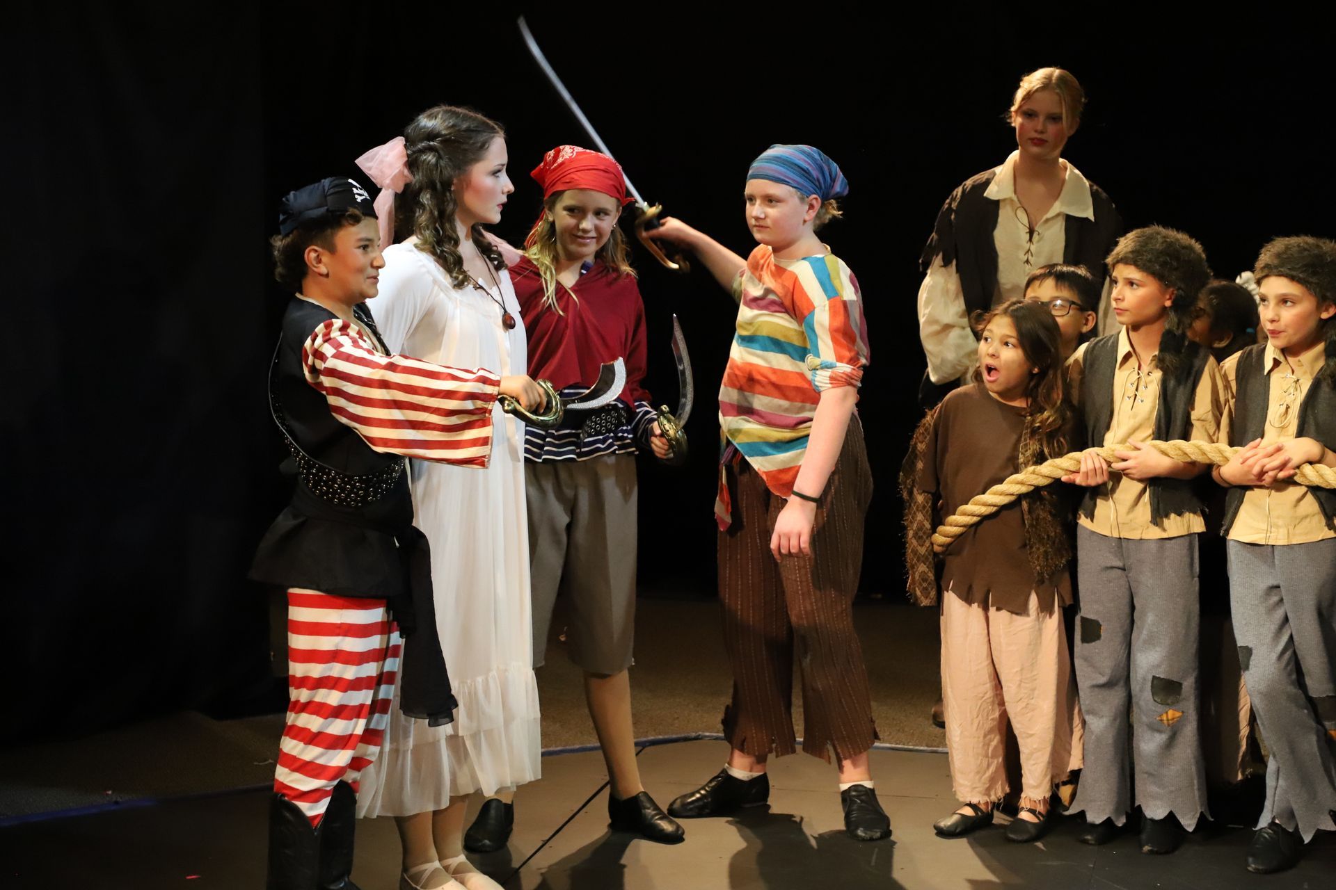 A group of children dressed as pirates on a stage