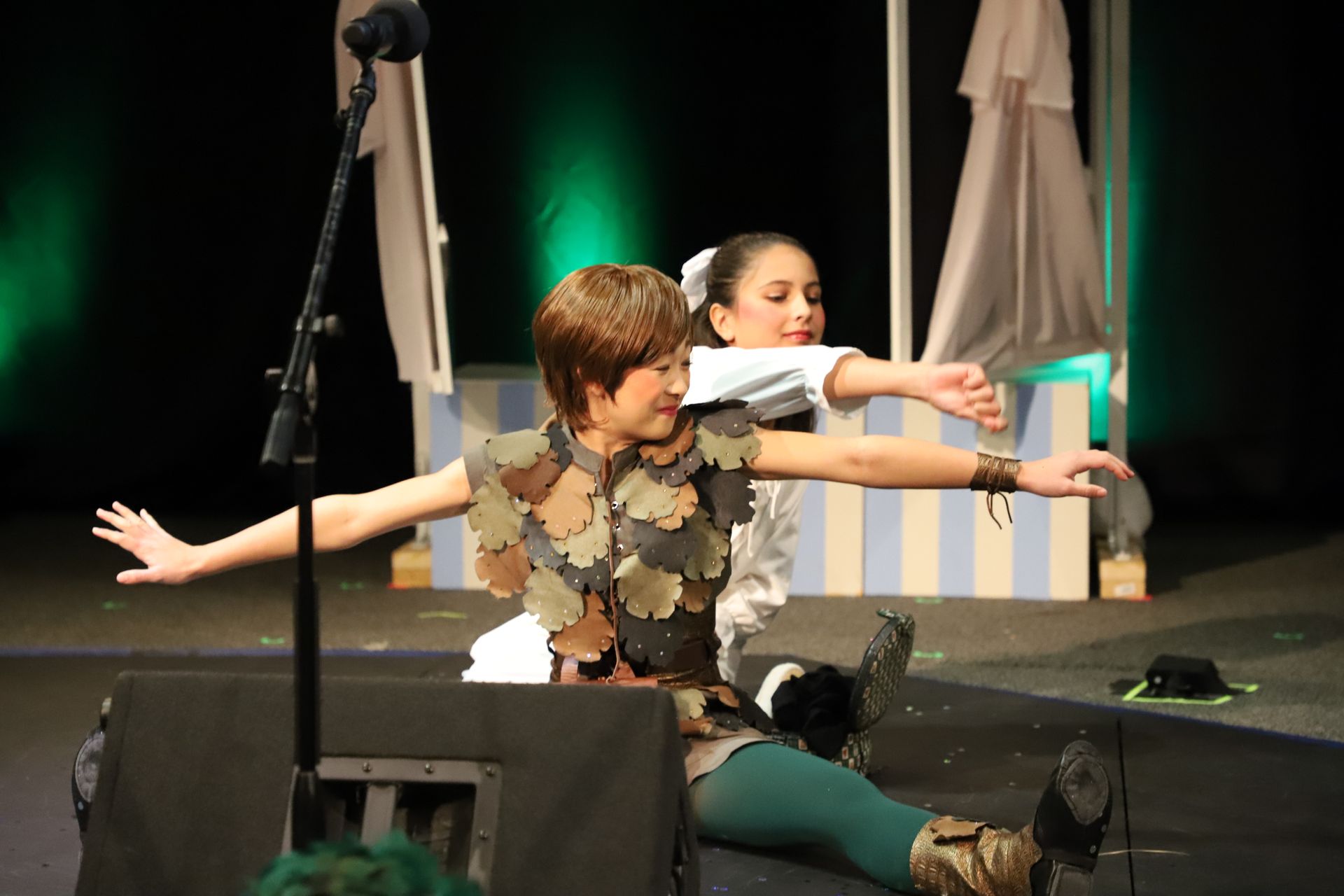 A boy and a girl are playing peter pan on a stage.