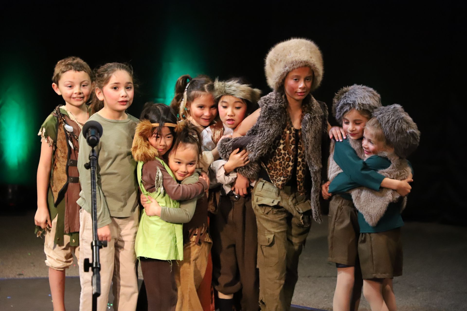 A group of children are standing next to each other on a stage.