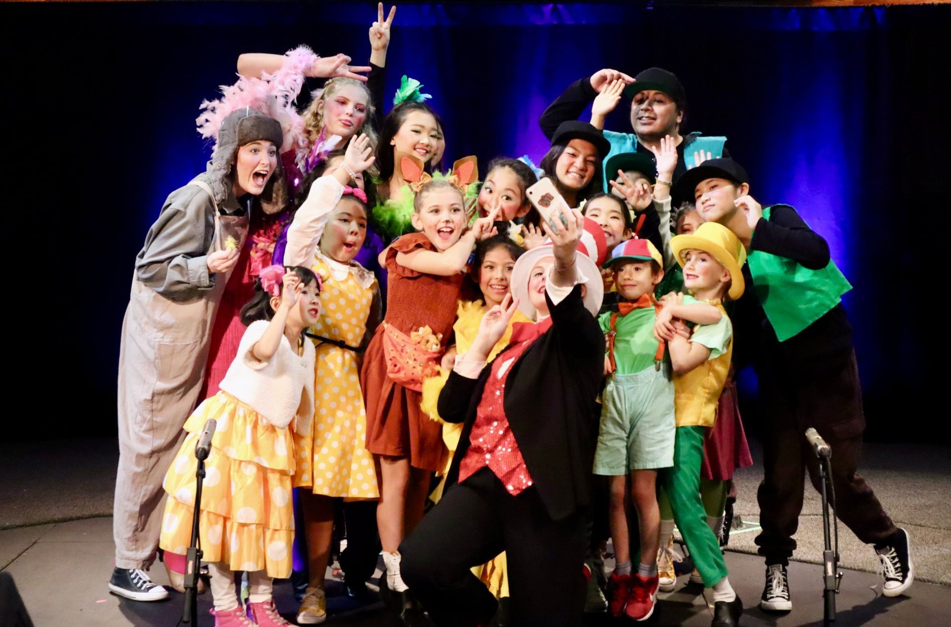 A group of children are posing for a picture on a stage.