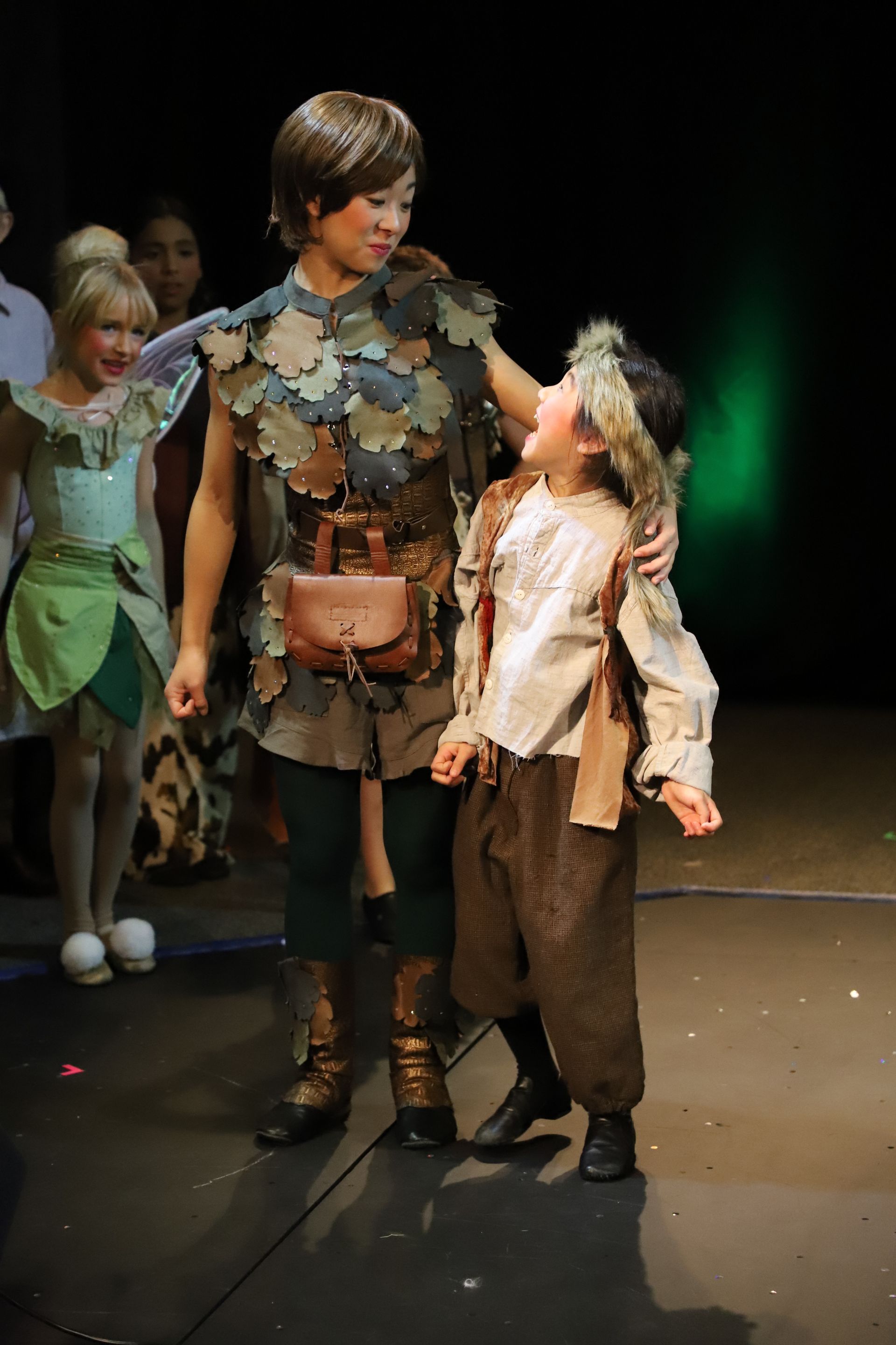 A man and a boy are standing next to each other on a stage.