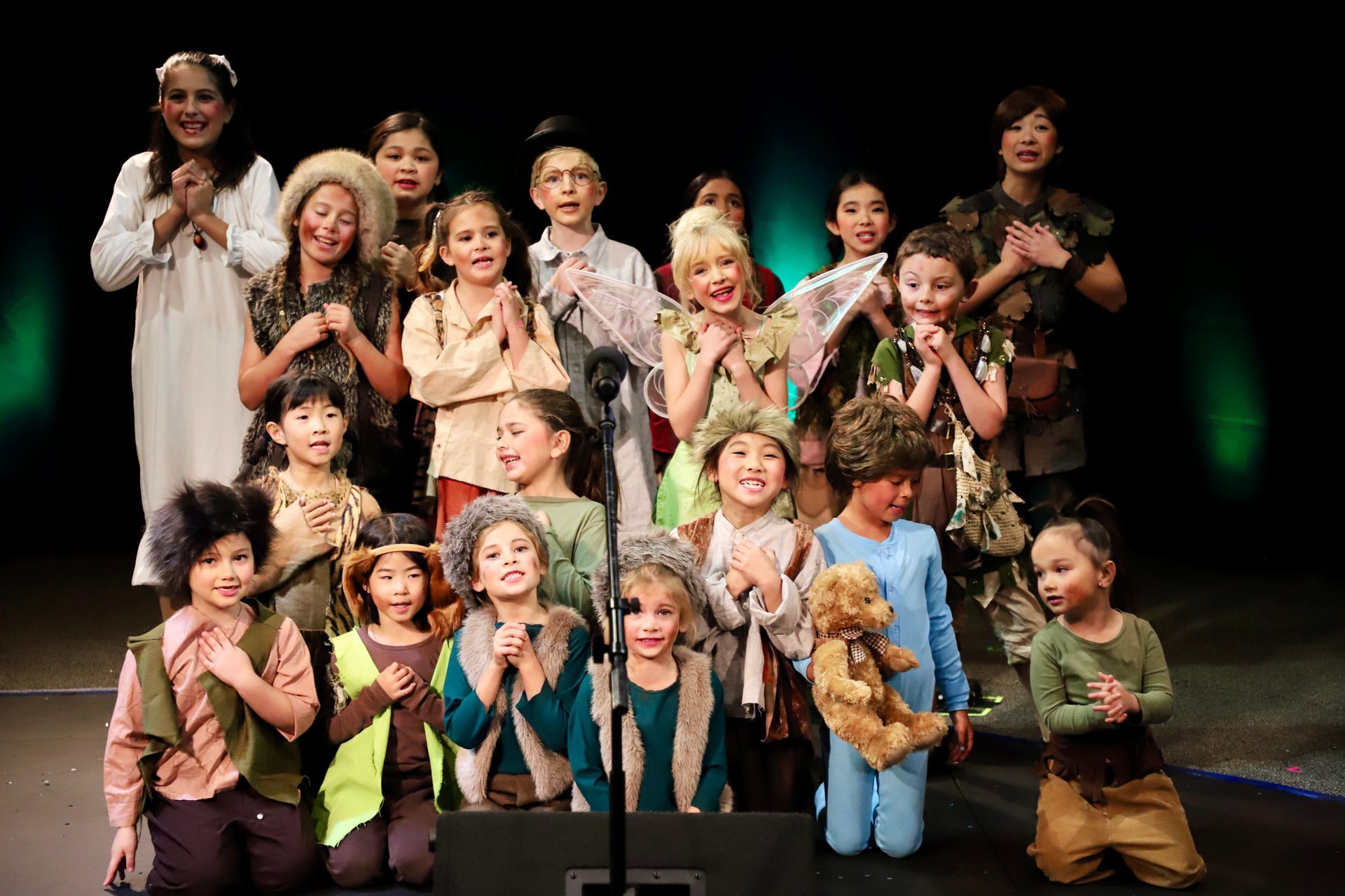 A group of children are posing for a picture on a stage.