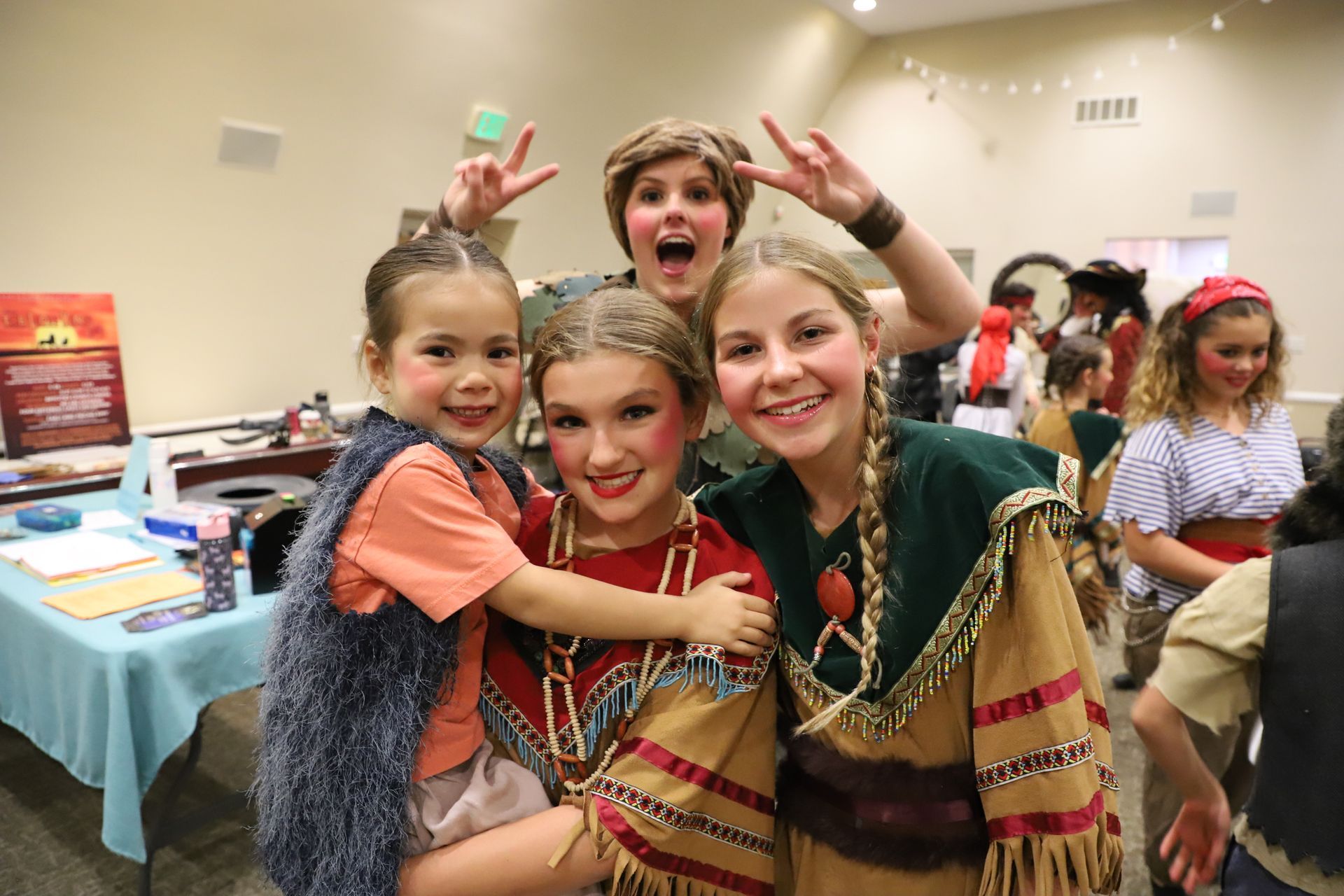 A group of young girls dressed in native american costumes are posing for a picture.