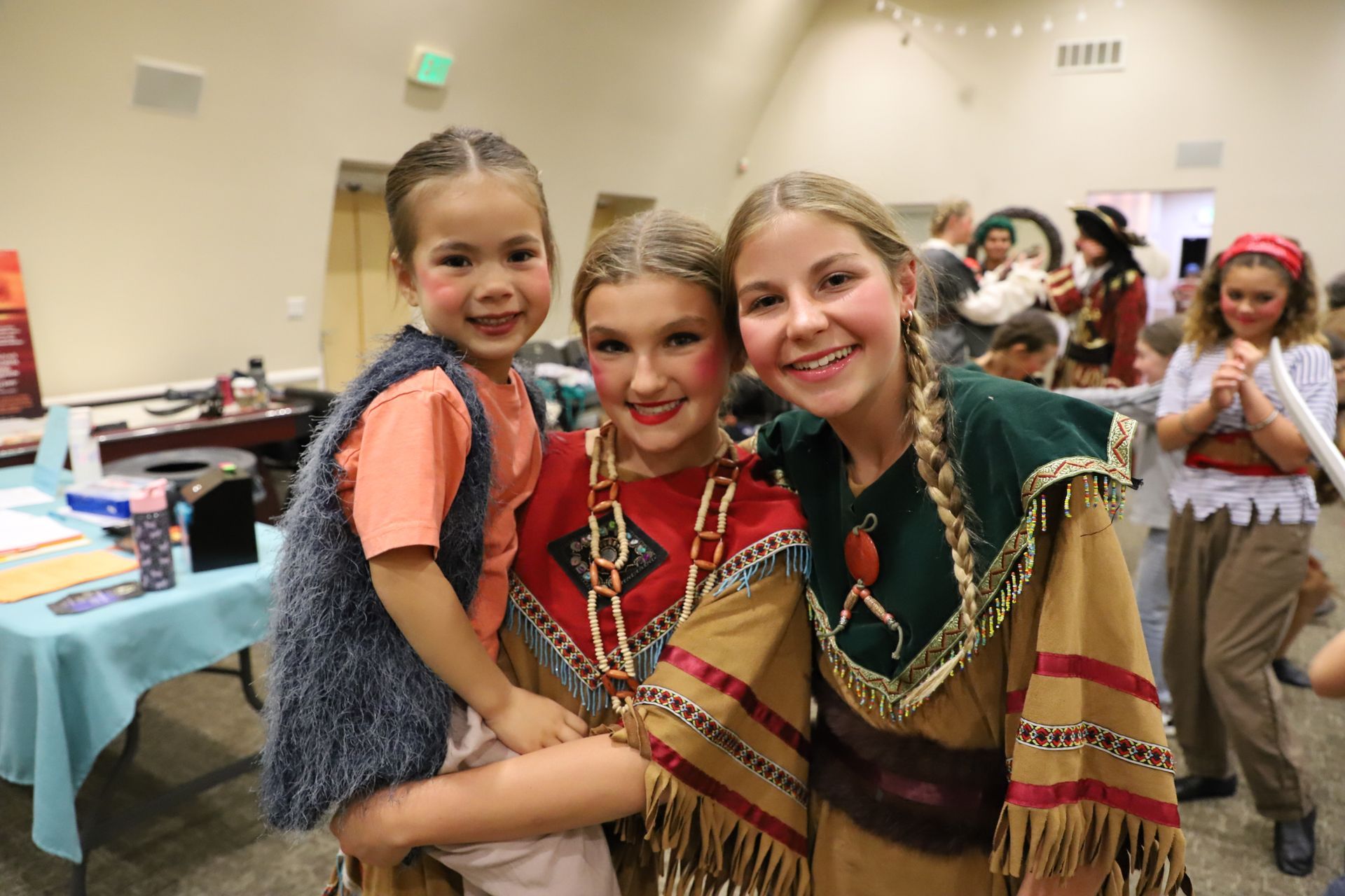 Three young girls in native american costumes are posing for a picture.