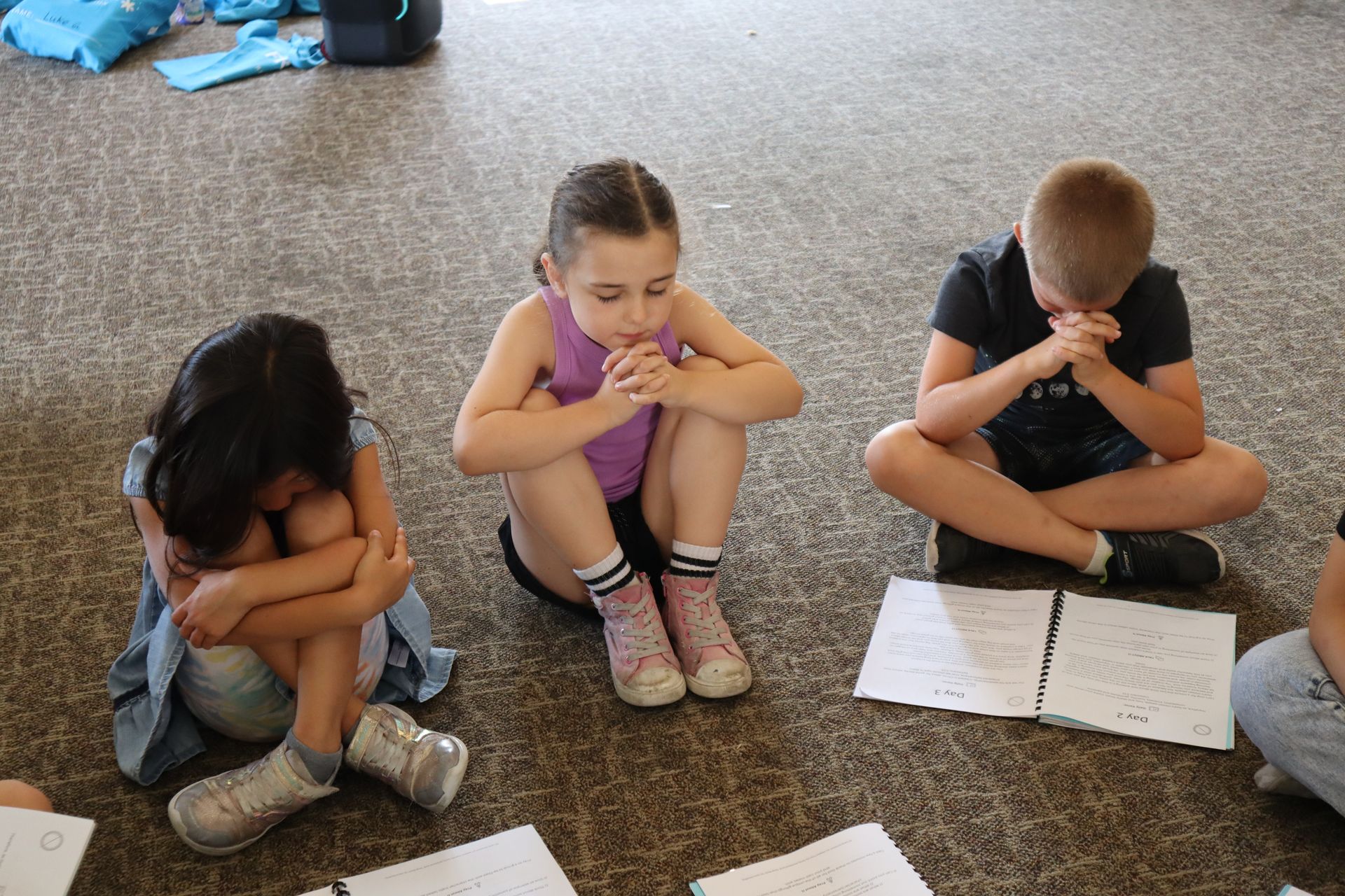 Three children sitting together and praying