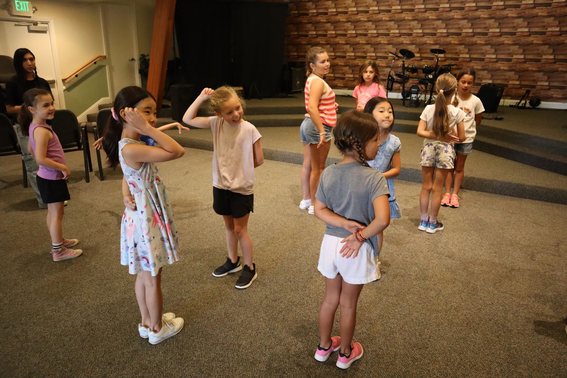 A group of young girls are standing in a circle in a room.