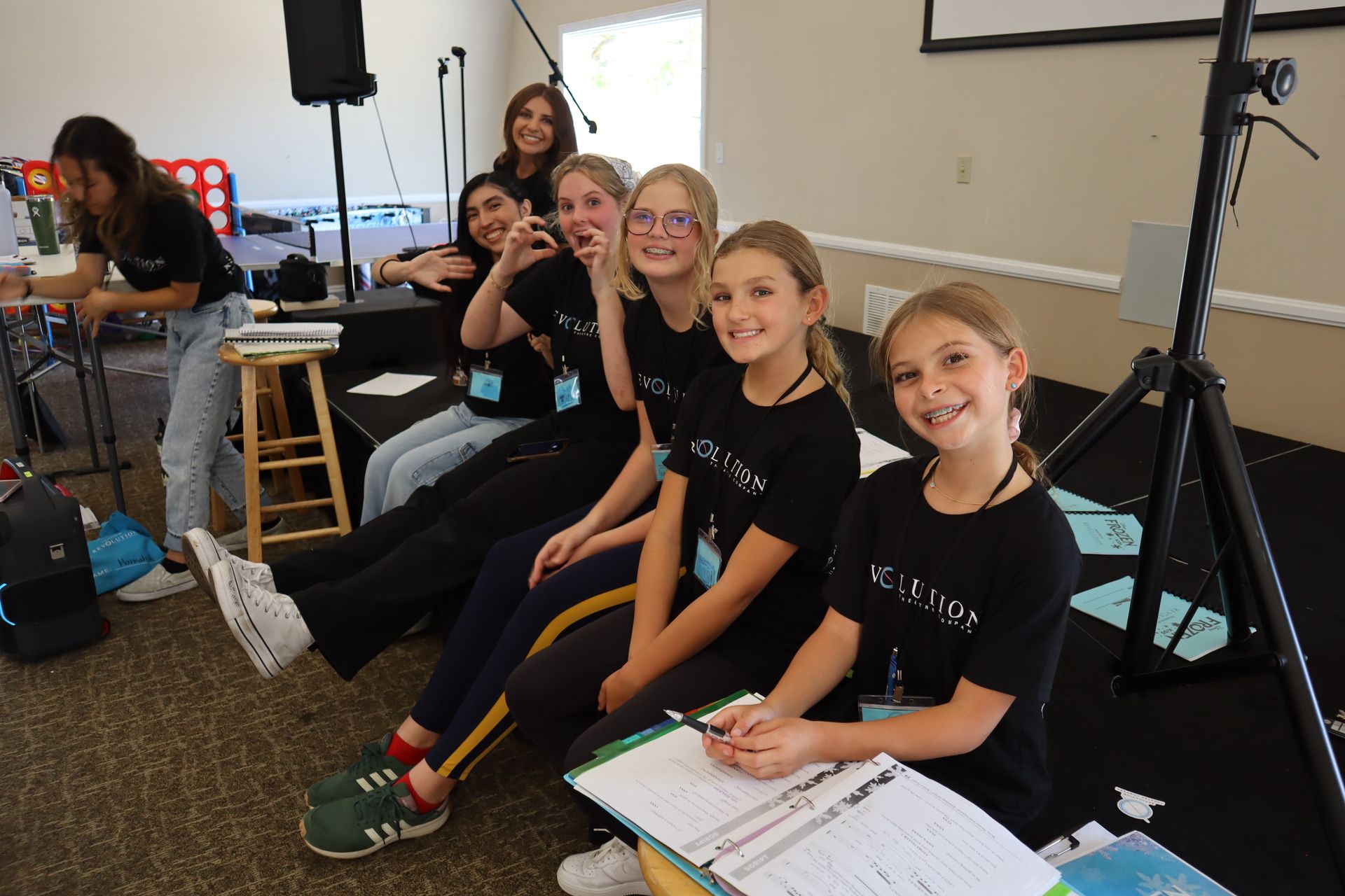 A group of young girls are sitting on the floor in a room.