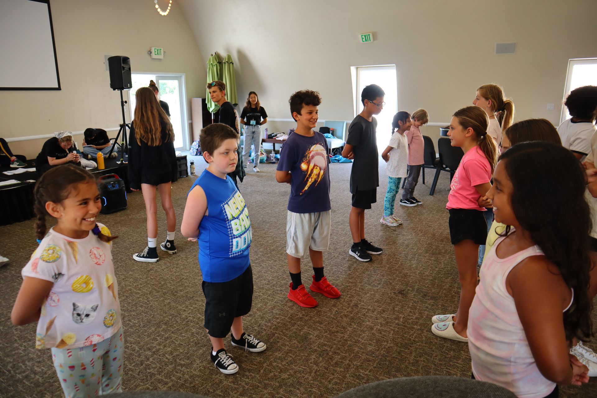 A group of children are standing in a circle in a room.