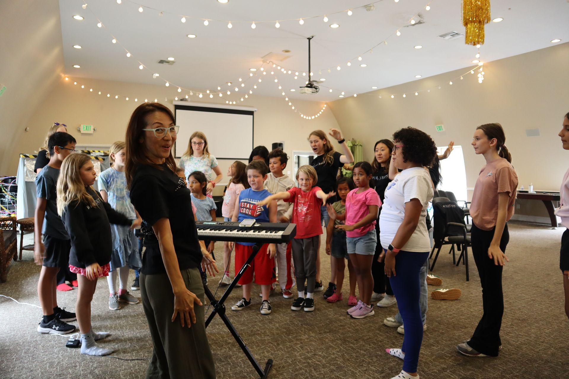 A group of children are standing around a keyboard in a room.