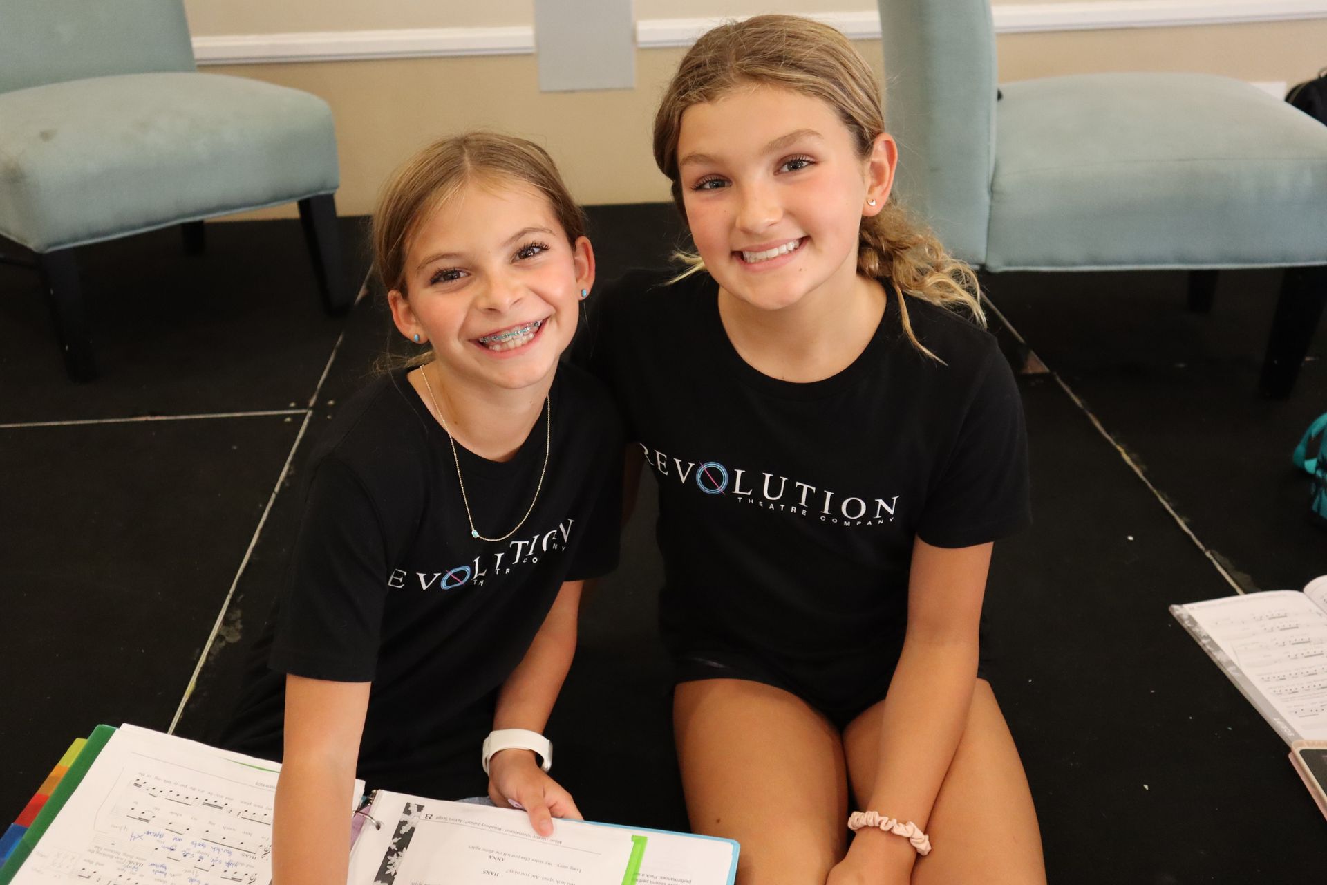 Two young girls wearing black shirts with the word evolution on them