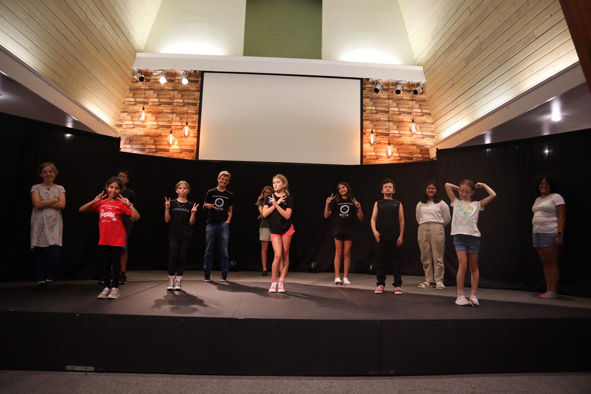 A group of people are standing on a stage in front of a large screen.