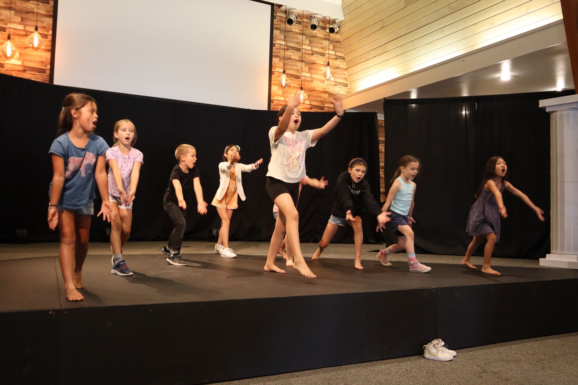 A group of young girls are dancing on a stage.